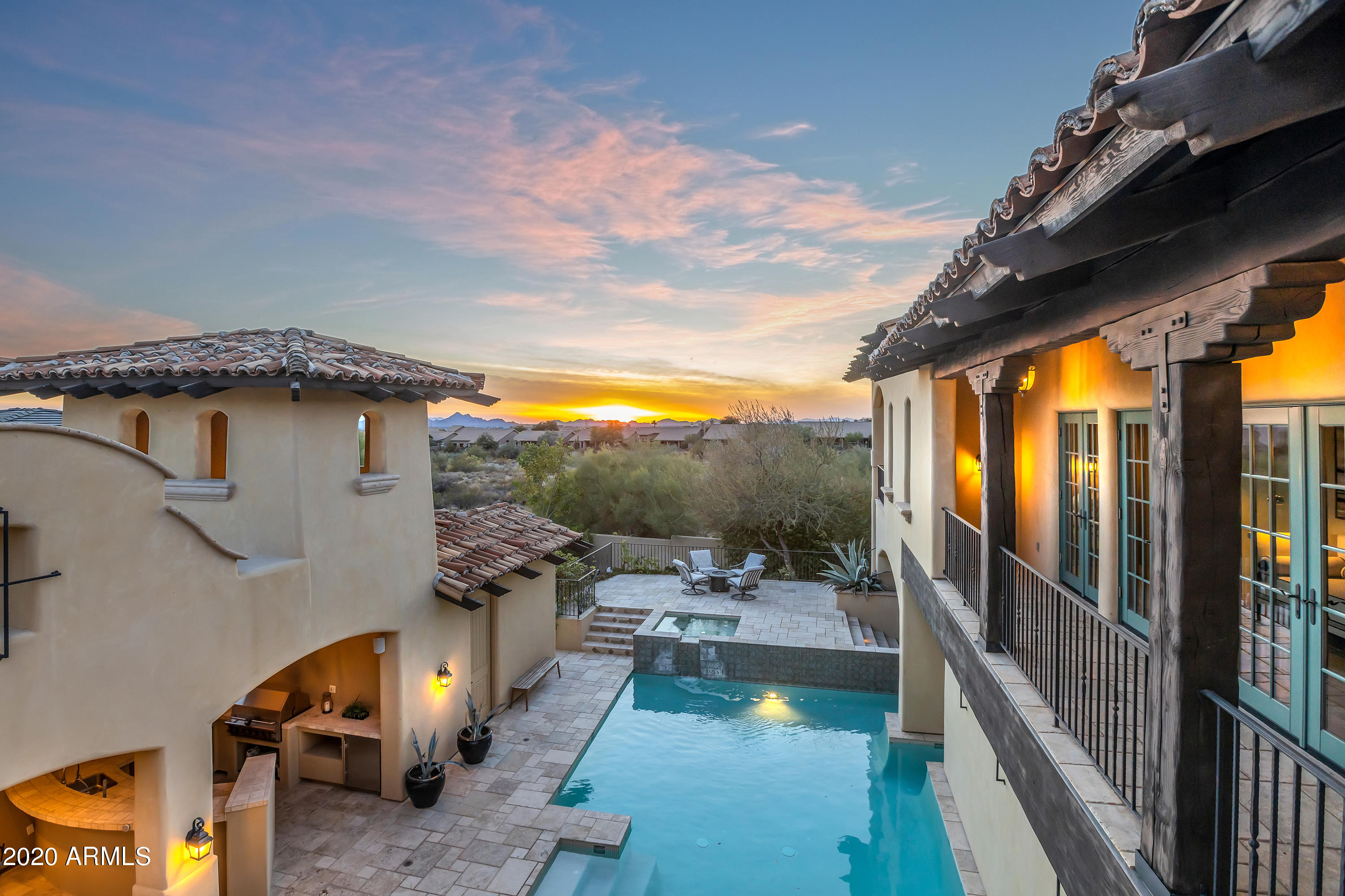 Nestled in the quiet, picturesque Arcadia neighborhood of Silverleaf at DC Ranch, this Spanish Contemporary home rises majestically above the tree lined street.  The abundance of glass, and glimpses of soaring spaces inside are captivating as you approach the front entry. The foyer is flanked by an open staircase to the upper level & an appealing sense of awe as the great room fireplace rises to meet the expansive timbered vaulted ceilings. The home boasts full wall electronic disappearing glass doors between the great room & the courtyard creating a beautiful blend of indoor/outdoor living. Next, a cooking delight. Spacious kitchen with island, Wolf range, oven & walk in pantry. Full size atmospherically controlled wine room located conveniently by the formal dining. Cont. The French doors lining the upstairs hallway lead to a surprise outdoor balcony & viewing area, perfect for sunset gazing. Dual master bedroom suites and two additional bedrooms boast spacious closet space & balconies. Office space, ample laundry & access to 3 car garage, from the Main floor. Intimate pool and spa area with travertine pool decking, generous pool house with private bath, and access to guest quarters. The upper patio provides perfect seating for the desert climate. Spacious guest quarters are complete with fireplace, bar, full bath, washer & dryer hookup & a private entrance off the driveway. Exceptional community, exceptional home, exceptional life.