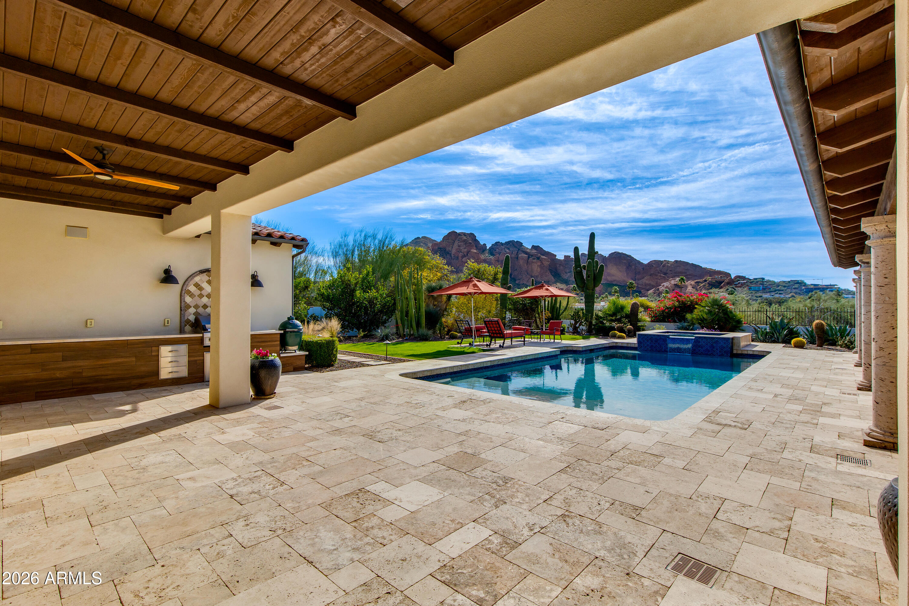 Welcome to this exceptional Spanish inspired home with iconic views and low maintenance lifestyle. This home was taken down to the original slab and thoughtfully rebuilt from the ground up. Every major system and finish has been transformed, delivering modern living without compromise. From the framing and roof to the electrical, plumbing, HVAC, insulation, windows, and drywall -- everything has been redone with quality craftsmanship and attention to detail. Upon arrival you will be ushered from the circular drive into the home where dramatic views of Camelback Mountain and a resort backyard await. Soaring wood beamed ceilings and an iron chandelier sit above an open concept kitchen filled with rich cabinetry and large entertaining island.  Walls of glass fully disappear for seamless indoor/outdoor flow. Outdoors, enjoy wide covered patios, manicured desert landscaping, and a heated pool with elevated spa, all set against stunning mountain views. Multiple lounging and dining spaces offer year-round enjoyment of Arizona's sunsets.  The thoughtful single-level layout features three ensuite bedrooms with patio access. The primary suite is a true retreat with a fireplace, a spacious walk-in shower, and a soaking tub.
This Paradise Valley jewel box offers the elevated lifestyle everyone dreams of, but without all of the hassle.
