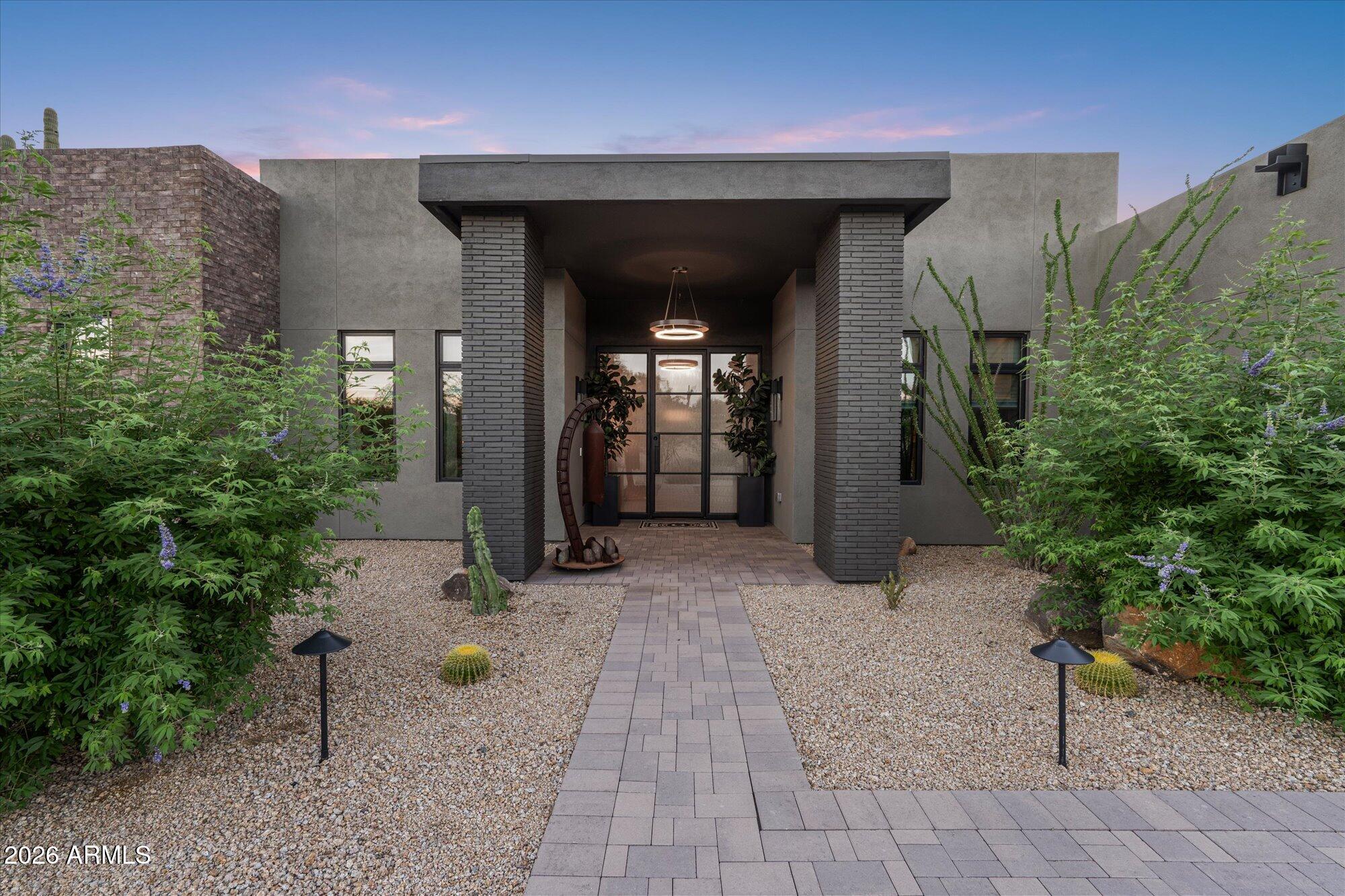 Completed in 2025, this custom home in Desert Ranch offers stunning mountain views and over $400k in thoughtfully selected upgrades, including builder enhancements and custom additions. Designed for effortless luxury, the home opens to a showpiece kitchen w Thermador appliances, lighted glass cabinetry and a double-waterfall quartz island. A fully disappearing five-panel glass wall creates a seamless connection to the covered patio and over $20k outdoor entertaining area w a built-in BBQ, pizza oven, cabinetry and quartz slab. More than $30k in front-yard landscaping enhances the home's curb appeal. Motorized shades, custom closets, en-suite bedrooms, rooftop access, garage A/C and smart-home features complete this exceptional Scottsdale retreat.
