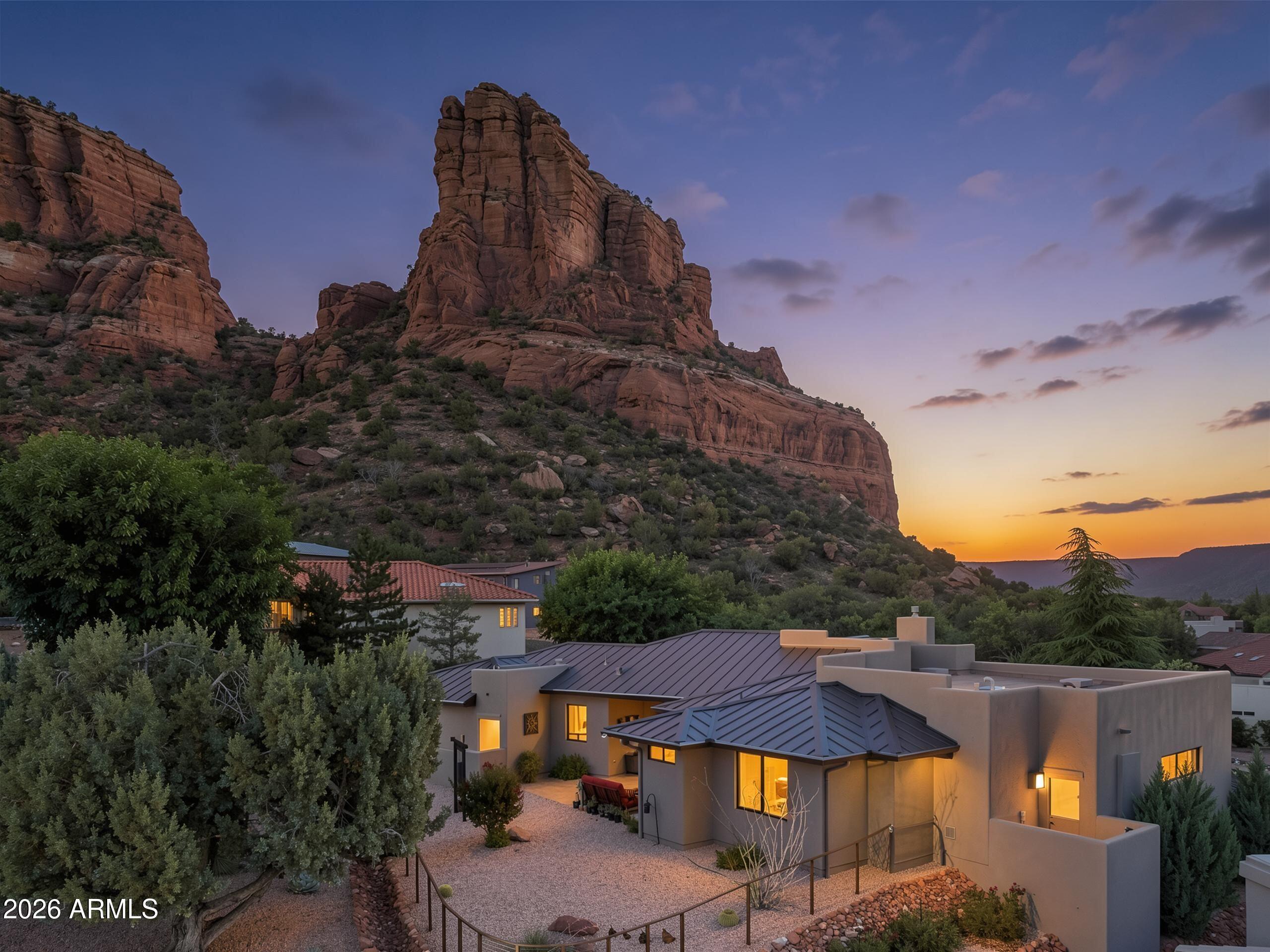 Wake up to the sunrise over Castle Rock, watch deer wander past your front patio, and end each day with breathtaking Sedona sunsets from your private backyard retreat.
Built in 2019, this beautifully crafted single-level Southwest contemporary home offers 3 bedrooms, 3 bathrooms, and 2,363 square feet of thoughtfully designed living space in the highly desirable Village of Oak Creek. What makes this property truly exceptional is its seamless connection to the natural beauty that surrounds it. Nearly every front-facing window captures stunning views of Castle Rock and Sedona's iconic red rock formations, creating a spectacular backdrop for everyday living.
The open-concept great room is filled with natural light and flows effortlessly into a spacious chef's kitchen featuring granite countertops, a large island, walk-in pantry, and quality finishes throughout. Outside, nature takes center stage. Deer regularly pass by on their way to favorite grazing spots, colorful birds visit throughout the day, and each spring the desert comes alive as native wildflowers and blooming cactus transform the landscape into a vibrant display of color.
The oversized two-car garage comfortably accommodates larger trucks and SUVs while providing generous storage for mountain bikes, hiking gear, golf clubs, and all the essentials for Sedona's active outdoor lifestyle.
More than a home, this is a place where every sunrise, every season, and every sunset becomes part of your daily life.

Highlights:
*Aquasana whole house, water systems, ProGrade Rhino Max Flow 1,000,000 gallons, with salt, free water conditioner, pre-filter, UV filter with day counter. 2023
*Aquasana reverse osmosis unit under kitchen sink. 2023.
*New custom cabinetry and countertops built by original Cabinetmaker - in laundry room installed in 2025.
*New kitchen island lighting. 2026
*New custom chandelier in dining room room. 2026
*New living room fan with light. 2026
*Steven Eagle Design, custom decorative, metal, fencing, and gates in backyard. 2025
*Exterior paint by the "House Whisperer," Roger Merrill. 2024.
*Hunt Douglas PowerView smart shades in all rooms and sliding doors. (Shades in bedrooms are blackout).  PowerView automation moves, shades to your daily plan via your computer or phone or simply use a hand controller. Enhances security while you're away by scheduling shades to automatically raise and lower at set times, and can also be controlled by Alexa or Google. 2024
*Leutron Caseta SMART light switches in all rooms. programmable to come on at any time of day or night. Can be controlled by Alexa or Google. Bedside remote controls to turn lighting off from bed without getting up to use a light switch. 2024
*Ethernet drops in five places in the home - kitchen, living room, master bedroom, second bedroom and third bedroom/office.
*Quickset smart front door lock. 2023.
*Prestige Heavy duty, custom security screen door leading to back patio. 2024
*Replaced outdated carpeting from bedrooms number two and number three and replaced with hardwood floors to coordinate with  the doors and other wood in the home. 2023
*Chaimberlain SMART garage door opener. Open and close your garage door remotely from anywhere in the world. 2023.
*Gas and water plumbed to back patio suitable for gas grill or build your own outdoor kitchen. 2019