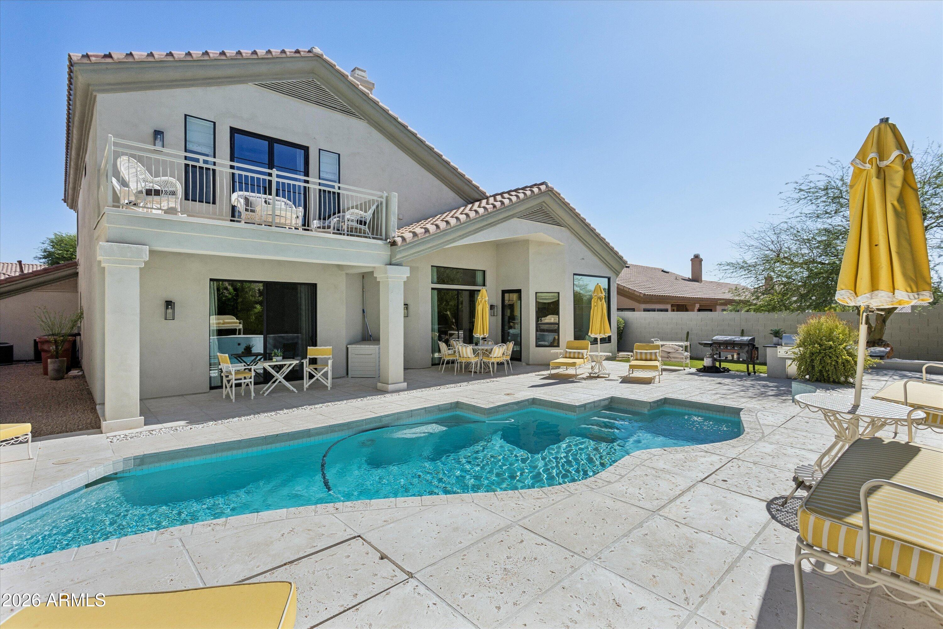 Designed with a polished modern feel and an easy sense of livability, this 4-bedroom plus den Scottsdale residence offers 3,516 square feet, 3.5 bathrooms, and thoughtful details throughout. Natural light fills the home, highlighting white oak hardwood floors, clean modern finishes, and an open layout that connects the main living spaces with ease. A full wall of paneled glass brings character and light into the office, while the two-story fireplace creates a strong focal point in the family room. The kitchen feels elevated without being overdone, with Calacatta quartz counters, fluted banco seating, frameless natural wood cabinetry, and premium appliances. The floor plan offers excellent flexibility, with two ensuite bedrooms on each level, making it ideal for guests, work-from-home needs or multi-generational living. Spa-inspired bathrooms and a resort-style pool complete the home, all in a convenient Scottsdale location close to both the elementary school and high school.