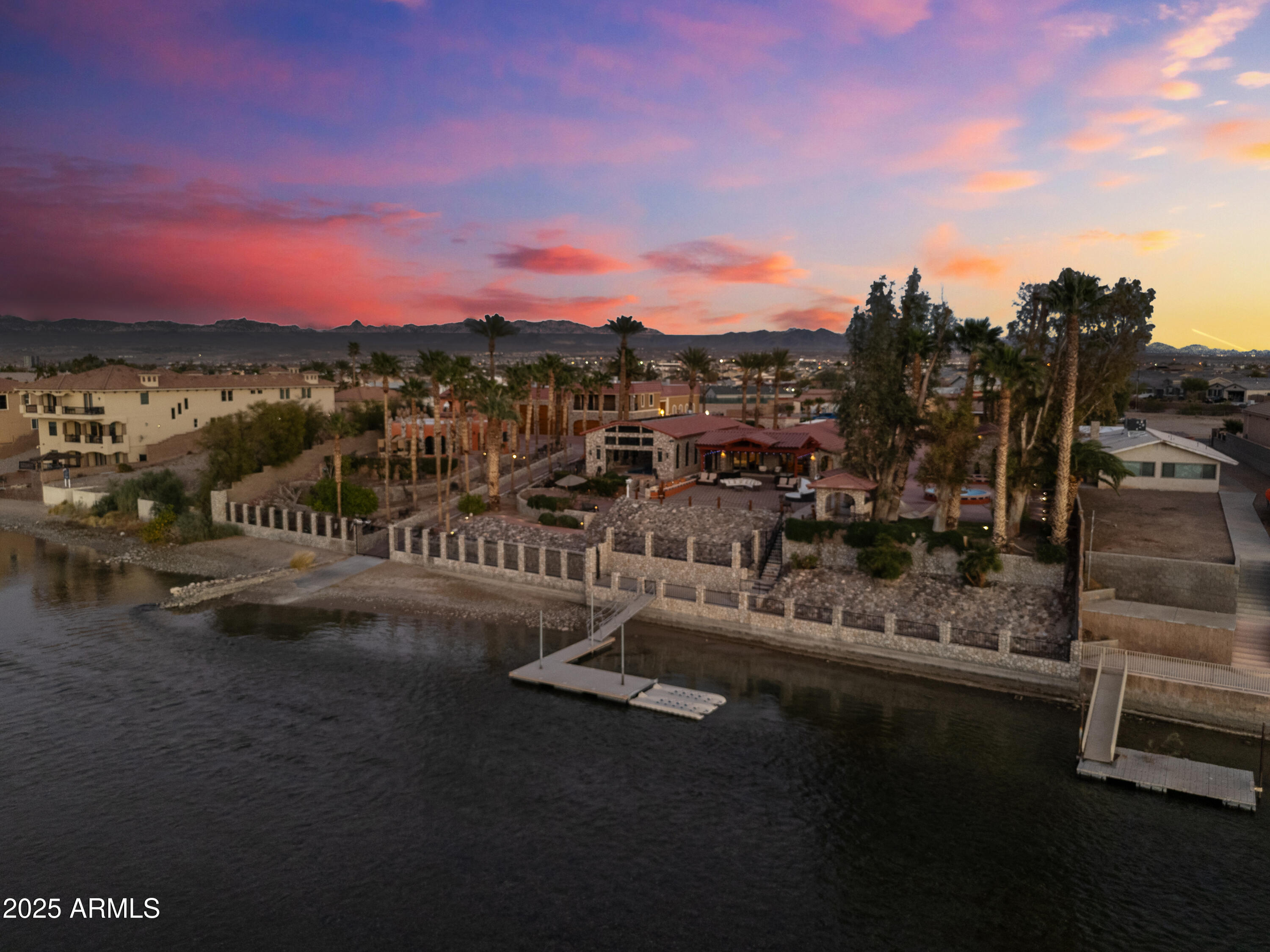Unique Riverfront Residential Compound set upon the Colorado River in Bullhead City , AZ. Includes 4 separate residences and an exquisite 7,000sf ''Show Car'' main garage spanning over 5 lots together on one residential, approx.1.38 acre property, with both open and shaded patio decks throughout. The Main Garage has to be seen to be believed: ample room for multiple cars, boats and RV's; 4 hydraulic lifts; full mechanic's workshop; floor drains; vents and bathroom. Main Residence is 2Br/2 Full bths & 2 Half bths, featuring an extra room that can either be a 3rd bedroom or wine cellar; 2br/1bth Guest House; 1br/1bth Guest Cottage; and a 2br/2bth Apartment on top of the main garage. A newly constructed boat/.jet ski dock and a loading ramp to the River.