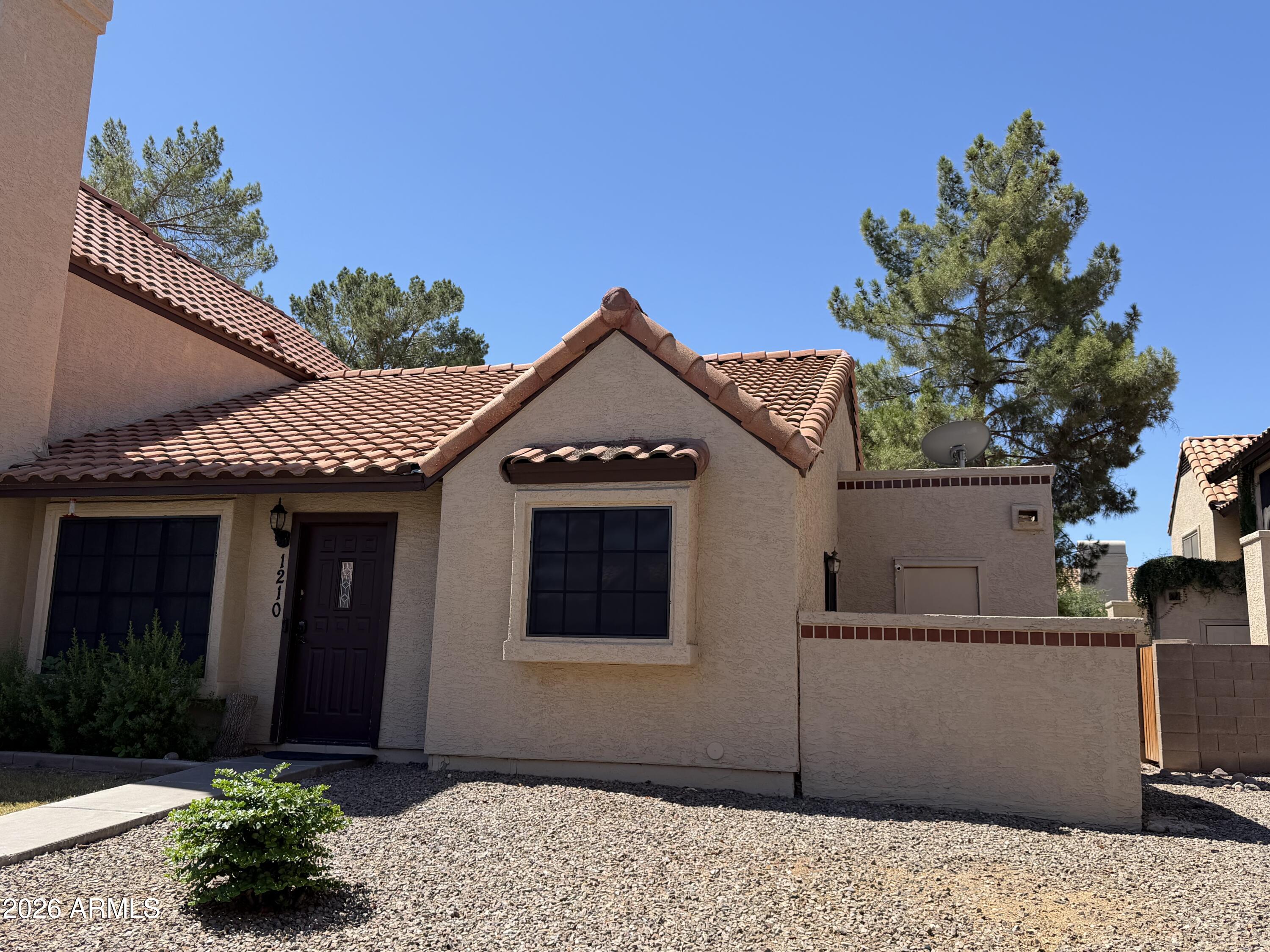 Fantastic end unit tri-level townhome with private side patio space and a charming, highly livable floorplan featuring vaulted ceilings and a cozy fireplace! Offering 3 bedrooms, 2 bathrooms plus a flexible den/office/game room in 'basement' (half in ground) space. Private walkway entry with living room and kitchen on the main level. Split-bedroom layout includes one bedroom downstairs and two upstairs with a Jack & Jill bath. Includes washer, dryer & refrigerator, motorized Designer blinds, desirable N/S exposure, and convenient dedicated covered parking just steps from your front door. Ideally located near the 101 & 202 freeways, spring training ballparks, shopping & dining. Lush green community with 2 sparkling pools. 6-month minimum lease preferred.