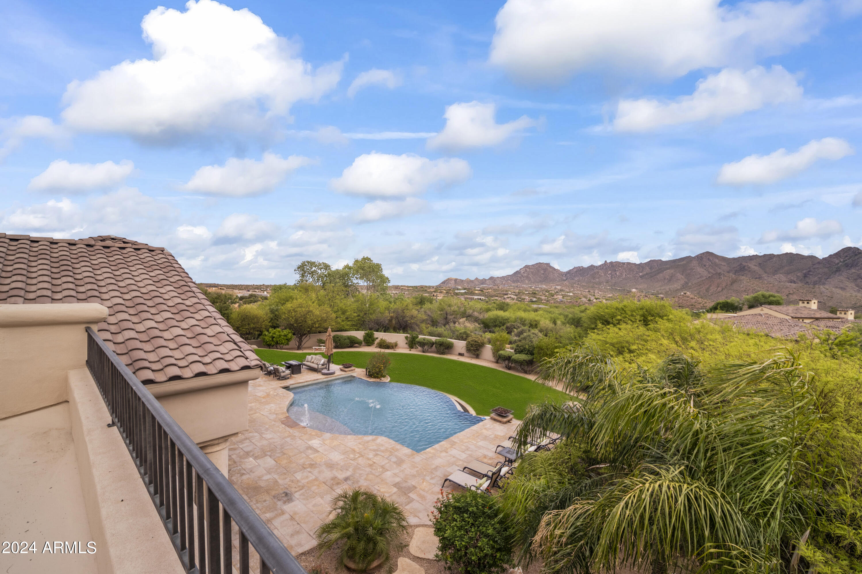 Widely regarded as one of the finest mountain view lots in Scottsdale, this privately gated Troon North estate captures unobstructed panoramas that rival nearby land-only parcels selling in the $4-5 million range. Set on over three elevated acres at the end of a quiet cul-de-sac, the property offers extraordinary privacy, scale, and scenery -- all without an HOA.
Surrounded by lush, mature landscaping with more than 75 trees, the setting feels remarkably serene while remaining just minutes from North Scottsdale's premier golf, dining, and shopping. Designed in collaboration with Graffin Design, the residence was thoughtfully crafted as a true custom estate, with every space intentionally designed to maximize natural light, flow, and the exceptional views. From the moment you arrive through the custom wrought-iron gate and follow the long private drive, the sense of privacy and arrival is unmistakable. Inside, walls of glass open to expansive outdoor living areas, where the pool visually blends into the mountain backdrop beyond. Multiple covered patios, fire features, spa amenities, and an upper observation deck provide front-row seating to breathtaking mountain, sunset, and city-light views.
The chef's kitchen anchors the main living space and features high-end appliances, granite slab countertops, a generous center island, walk-in pantry, and a built-in popcorn machine  a distinctive detail reflecting the home's thoughtful customization.
The primary suite offers a private retreat with fireplace, spa-inspired bath with soaking tub and walk-in shower, dual vanities, and direct patio access. Just outside the primary spa bath, an extremely private outdoor shower delivers a tranquil, resort-style experience. Two additional guest suites feature ensuite baths, walk-in closets, and exceptional outlooks. A beautifully appointed office with French doors to the courtyard includes custom built-ins, a painter's sink, and a built-in sewing station. A flexible media room with custom bookcases provides space for entertainment or can easily function as a fourth bedroom.Outdoor amenities include:
"	Resort-style pool with integrated water features
"	Built-in BBQ and prep station
"	Poolside firepots and deck jets
"	Two outdoor showers, including an extremely private shower just outside the primary spa bath
"	Raised dog wash station with hot and cold water
"	Expansive upper deck ideal for sunsets, stargazing, and city-light views
Car enthusiasts will appreciate the oversized 4.5-car garage, thoughtfully designed with tall ceilings, a vehicle lift, extensive built-in cabinetry, a sink-equipped workbench, and over 200 square feet of enclosed storage or workshop space  with the ability to expand to easily accommodate 6+ vehicles.
Ideally located just five minutes from Troon Country Club, where golf and social memberships await, and moments from Troon North's Monument and Pinnacle courses, Scottsdale National, fine dining, and upscale shopping, this estate offers an exceptional balance of privacy, greenery, and convenience.
For buyers who understand land value, view corridors, and long-term scarcity, this property represents an extraordinary opportunity. Simply put, you will not find a better mountain view at this price point in Scottsdale.