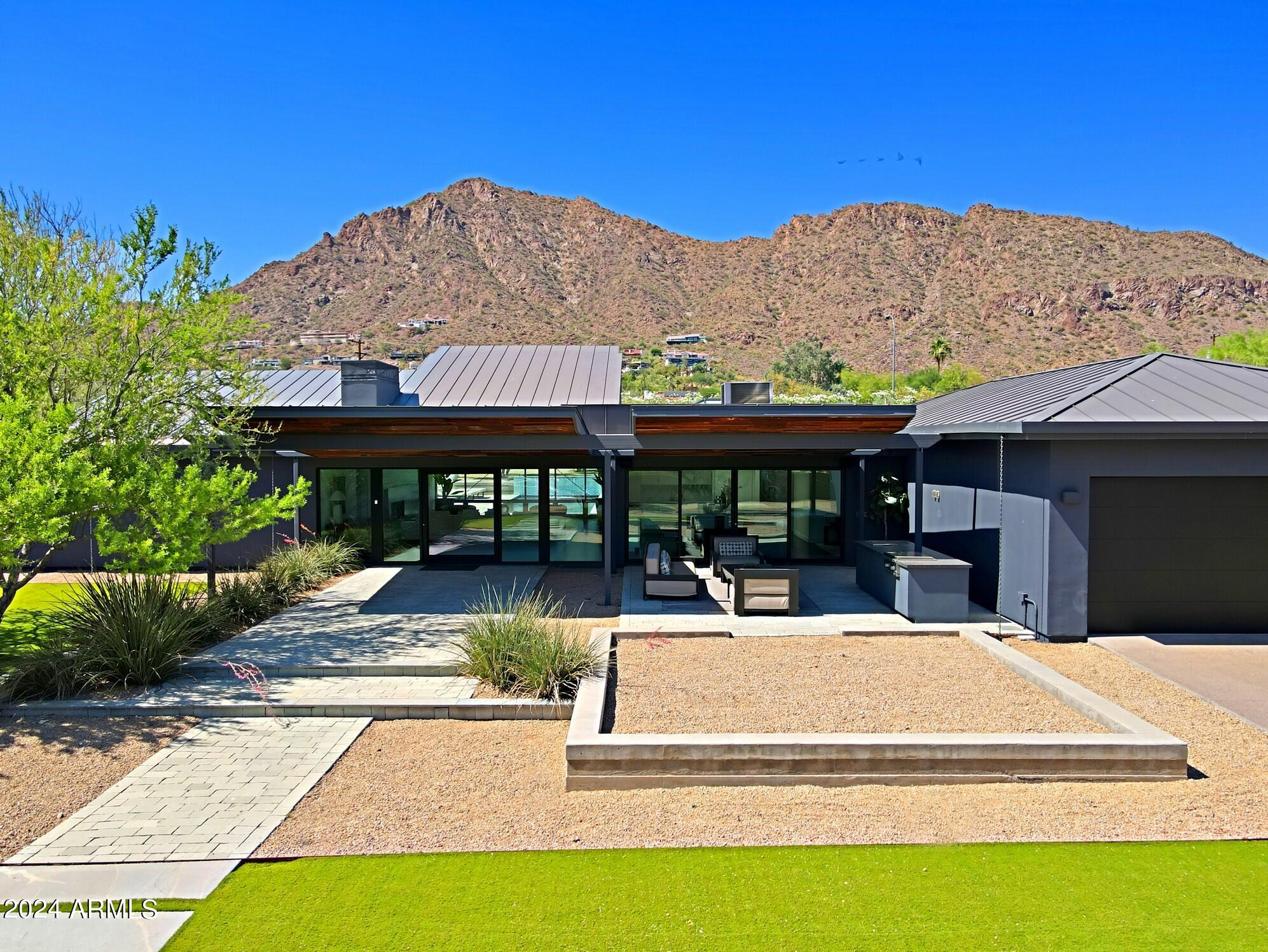Welcome to a one-of-a-kind masterpiece nestled in the heart of Arcadia, offering unparalleled views of Camelback Mountain and a sense of tranquility that is truly unmatched. This private sanctuary exudes a contemporary feel, blending modern design with the natural beauty of the desert landscape.Situated in an extremely exclusive gated community, this exquisite property boasts 4 BR, 3.5 bathrooms, and is set on a sprawling 3/4 plus acre lot, providing ample space for both indoor and outdoor living.From the moment you step foot onto the property, you are greeted with a sense of grandeur and sophistication that is sure to impress even the most discerning buyer. This is a rare opportunity to own a piece of art in the form of a home, where every detail has been meticulously curated to create a truly unique living experience.