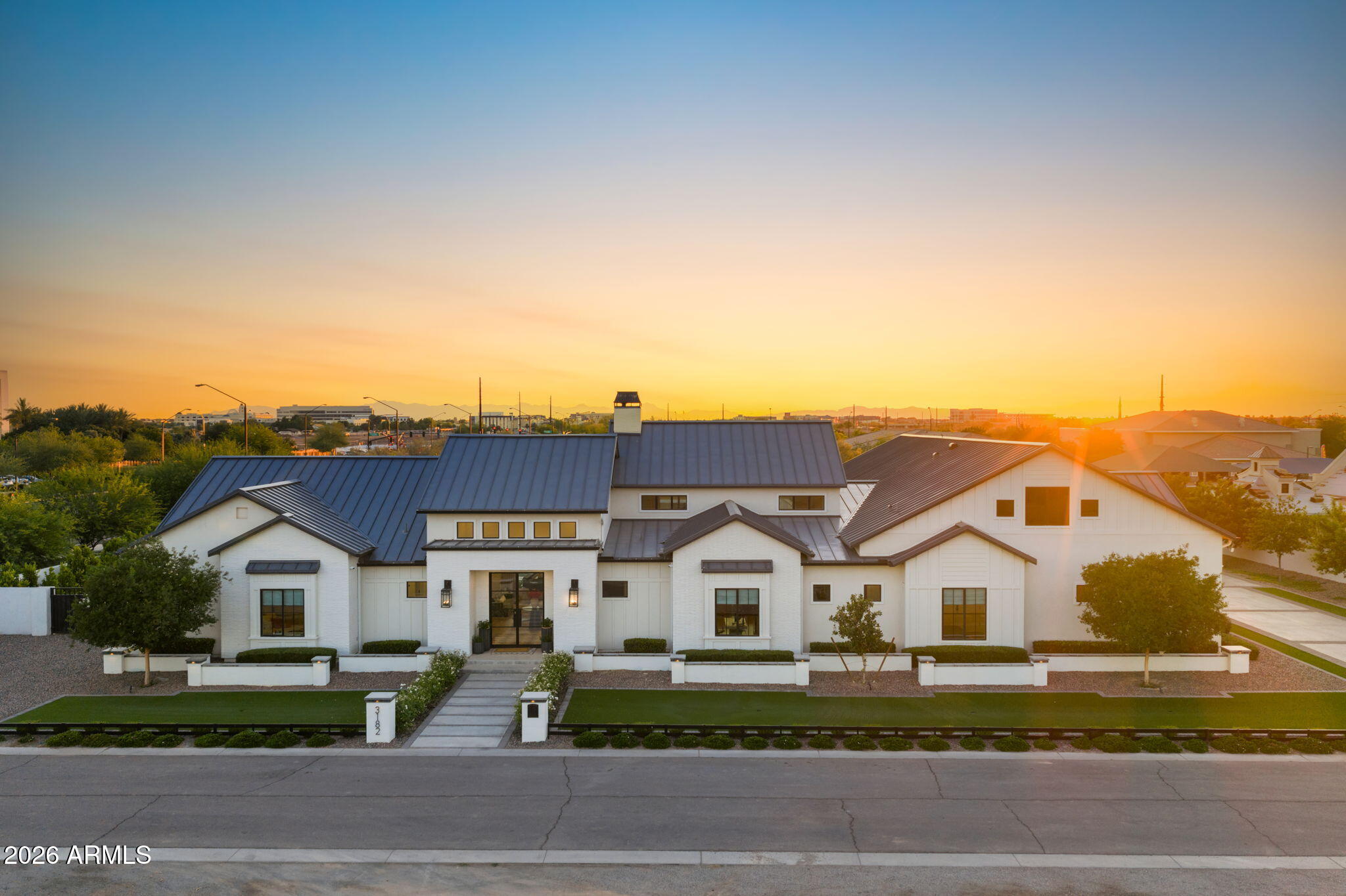 Located within the prestigious Temple View Estates community, this extraordinary estate offers luxury living on a beautifully landscaped one-acre homesite in the heart of Gilbert.
Designed for both grand entertaining and everyday comfort, the property features approximately 6,000 square feet of thoughtfully crafted living space, complemented by an 1,788-square-foot detached pavilion/guest house complete with its own kitchen and laundry facilities. An attached four-car garage and detached RV garage provide exceptional space for vehicles, recreational equipment, and storage.
The residence showcases a contemporary open floor plan highlighted by soaring 16-foot ceilings in the expansive family room, creating a sense of grandeur while framing stunning views of the resort-style backyard. French doors, generous windows, and seamless indoor-outdoor transitions invite natural light throughout the home.
At the heart of the residence, the chef's kitchen combines beauty and functionality with an oversized natural stone island, custom designer cabinetry, premium appliances including Sub-Zero, Viking, and Lacanche, and convenient access to a prep kitchen and spacious pantry. The adjoining breakfast area and gathering spaces open effortlessly to the outdoor entertaining areas.
The luxurious primary suite offers direct access to the backyard retreat, including the spa and outdoor living spaces. Throughout the property, thoughtful design elements create an atmosphere of quiet sophistication and modern livability.
The resort-inspired backyard is truly exceptional with views of the nearby temple and its illuminated evening skyline. Highlighted by a pool with LED Aqua Jets and waterslide, waterfall features, spa, firepit, sports court, misting system, and integrated sound system. Expansive patios and outdoor kitchen areas provide the perfect setting for entertaining on any scale.  Combined with mature landscaping and low-maintenance artificial turf, the grounds offer both beauty and practicality.