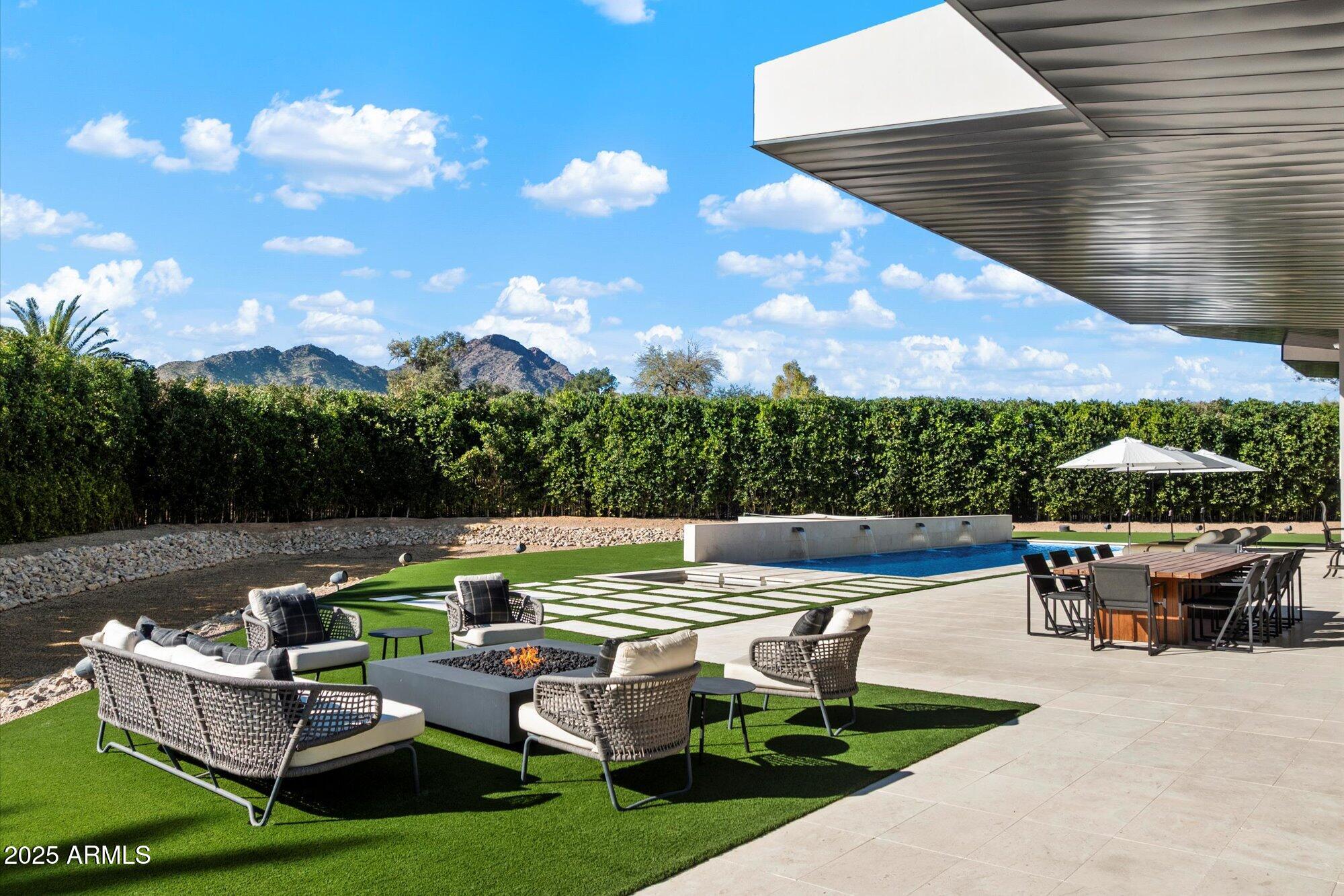 Stunning contemporary with clean lines, beautiful architecture, & dramatic oversized ceiling height with  5 Glass Retractable Walls that open to Camelback Mountain Views. This 7,825 sqft livable 1.14 Acre gated estate with Guard House, boasts a 6,365sqft livable main house & a 1,460 sqft livable Guest House
with mature landscaping.  Main House boasts a split floorpan with Primary Bedroom, Primary Sitting Room, Marble Primary Bathroom, 2 Primary Closets, Plus a Shoe/Purse closet. The Guest wing offers 3 oversized Junior Suites, and the Main Section of the home boasts a Chef's Kitchen open to the great room a formal Living, Dining Room, Wine/Tequila Room, & 4 Car Garage.  The massive Guest House boasts a separate Family Room, Dining Room, Kitchen, Ensuite & 2 Garages.