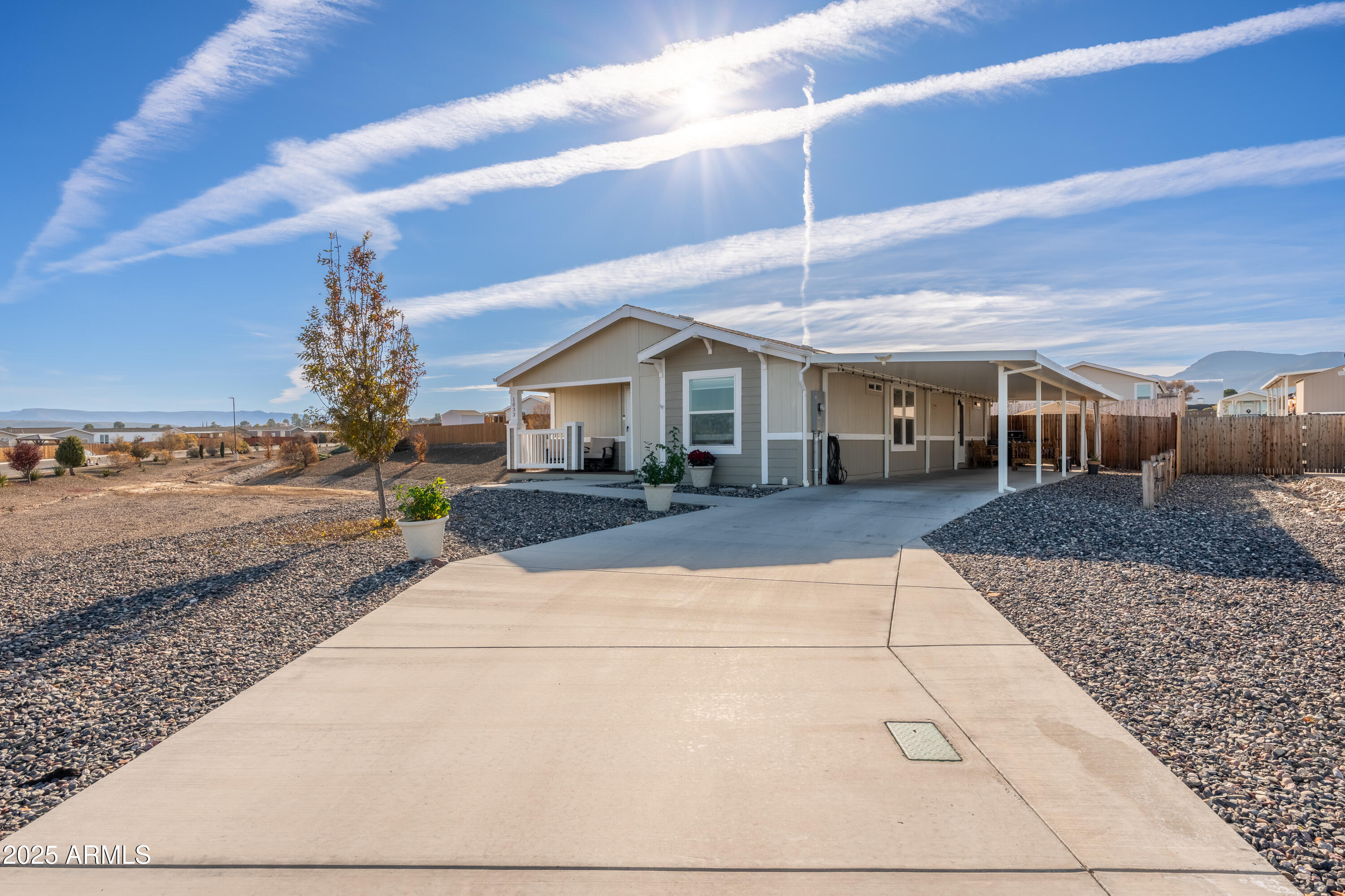 Welcome to this charming 3-bedroom, 2-bathroom 2021 manufactured home located at the end of a quiet cul-de-sac in the desirable Verde Ranch Estates community in Camp Verde. This home features a bright and spacious open-concept layout with luxury vinyl plank (LVT) flooring throughout, creating a clean and modern aesthetic. The split floor plan offers privacy and functionality, while large windows invite natural light and showcase scenic views of the adjacent common area. Outside, the property includes a double carport for covered parking, a fenced yard ideal for pets or gardening, and a storage shed for added convenience. Situated on leased land, this home provides affordable, low-maintenance living in an all-ages community that offers an impressive range of amenities including a clubhouse swimming pool, spa, fitness center, and gated access. Enjoy a peaceful neighborhood atmosphere with easy access to the Verde River, outdoor recreation, and nearby attractions in Cottonwood, Sedona, and beyond. This is a wonderful opportunity to own a newer home in a well-maintained, amenity-rich setting.