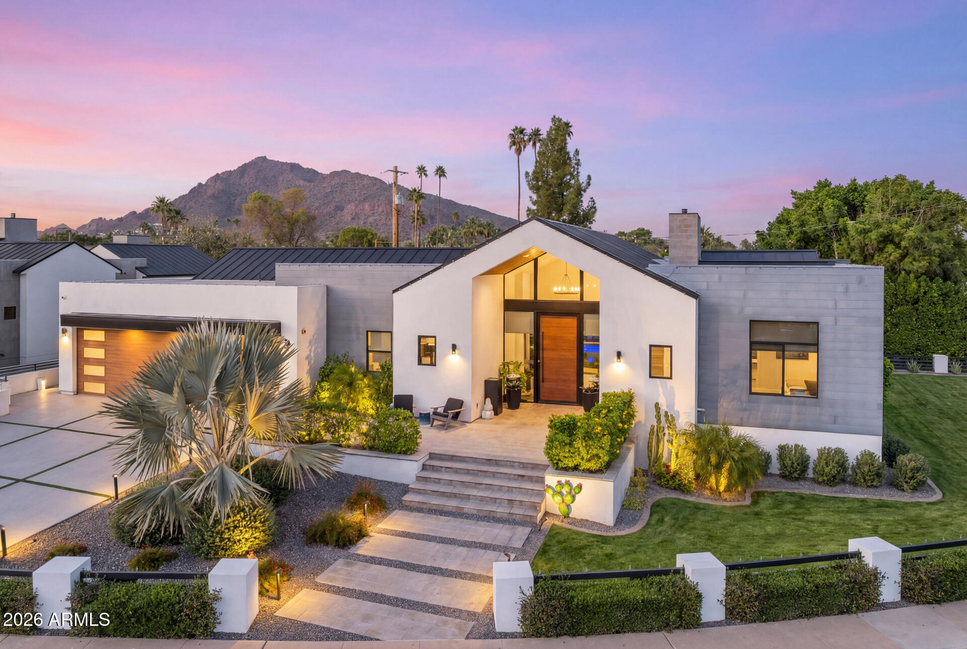 This modern, thoughtfully designed home is set on a premier corner lot in the heart of Arcadia Proper. Offering 4 bedrooms and 4.5 baths, the home features well-planned living spaces that balance comfort and style. The main living area showcases a striking marble fireplace and exposed beams, creating a clean yet elevated aesthetic filled with natural light.

The open gourmet kitchen is designed for both everyday living and entertaining, complete with sleek white cabinetry and a substantial Calacatta quartz island that flows seamlessly into the dining area. The primary suite offers a serene retreat with its own fireplace and floor-to-ceiling windows that frame peaceful views. The spa-like primary bath features dual vanities, a walk-in shower, soaking mature landscaping, and a covered patio ideal for dining or lounging. A private recessed outdoor sitting area adds an extra space to unwind or enjoy quiet time outdoors. Additional conveniences include a functional mudroom with built-in storage and a separate laundry room.