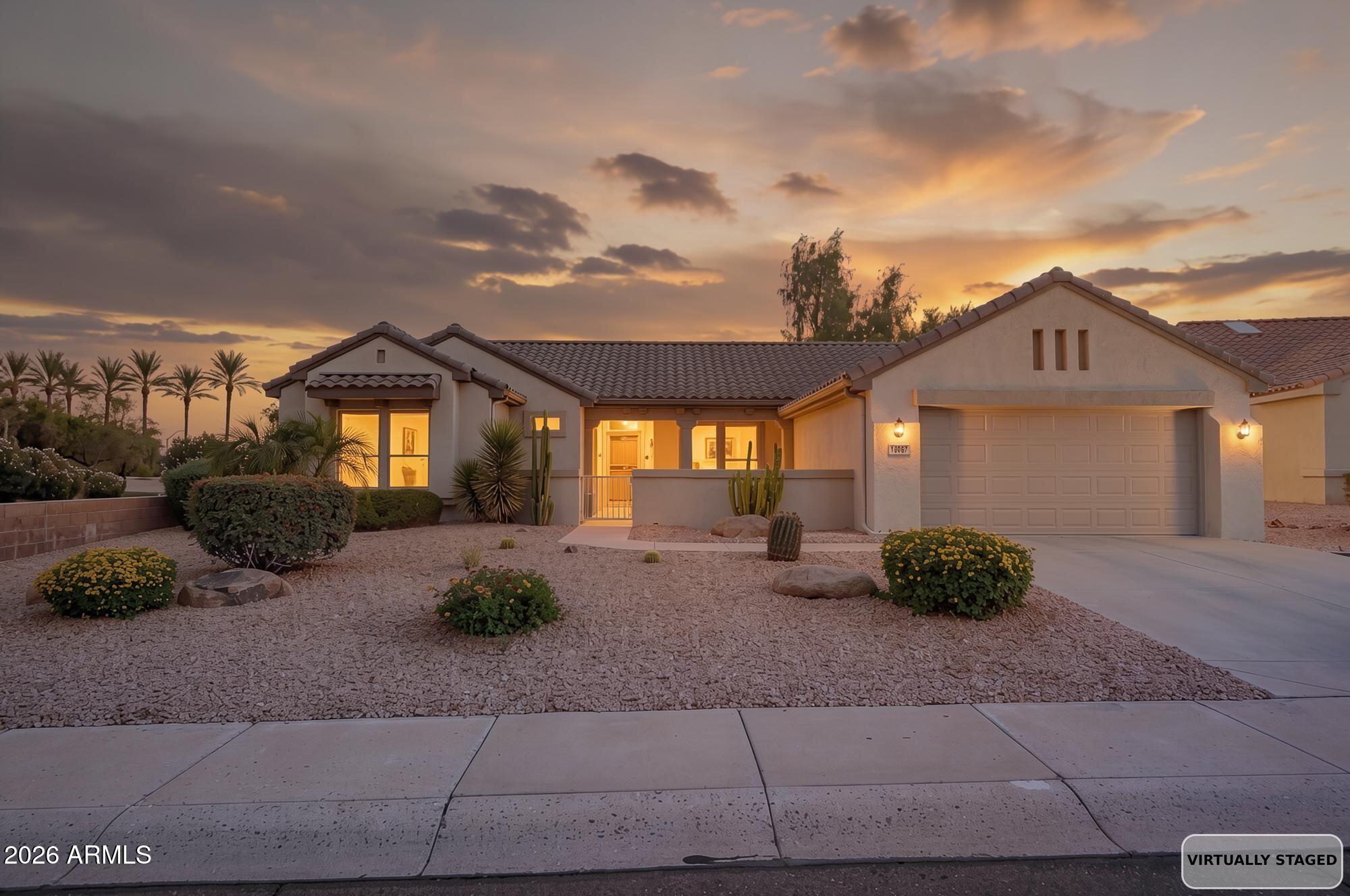 Welcome to easy living in Sun City Grand. This home gives you room to spread out with an extended garage, a flexible bonus space perfect for an office or den, and a formal living or dining room that opens through French doors to a large covered patio, ideal for morning coffee or evening conversation. The great room's triple sliding door brings the outdoors in and leads to a low maintenance backyard with AZ desert landscaping, backing to a common area for extra privacy. Practical updates give you peace of mind, with a roof underlayment fully replaced four years ago and an AC unit that's just three years old. Security screen doors on every entry add comfort and function. The washer and dryer stay, so you can move in and settle right in. Sun City Grand offers resort style 55 and older living with golf, pools, fitness centers, pickleball, and a full calendar of clubs and events, all just minutes from your front door. Come see what everyday can feel like here.