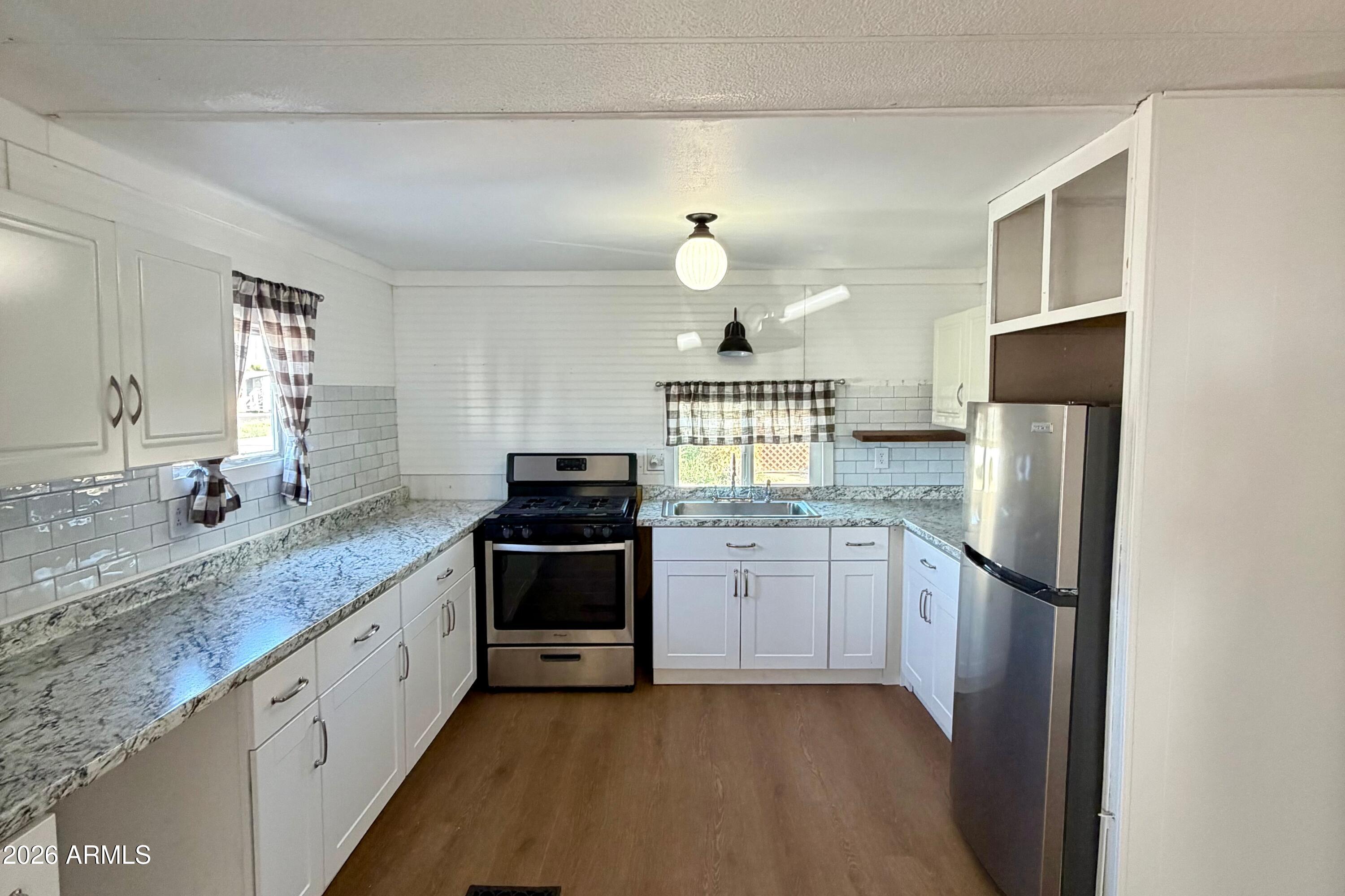 ***SELLER TO CREDIT BUYER AMT EQUAL TO 2 MONTH'S RENT AT CLOSING***Recently updated, this charming porch-front home is located in a desirable 55+ community offering a heated pool and spa, pickleball, shuffleboard, BBQs, fire pit, library, billiards, and a community room with kitchen--ideal for an active and social lifestyle.

The spacious kitchen features newer stainless appliances, white shaker cabinets with hardware, and a decorative backsplash. Wood-look laminate flooring runs throughout and the flexible floor plan allows for comfortable dining, office or guest spaces.

Enjoy relaxing sunsets on the secondary patio, along with ample storage and the added benefit of a newer A/C and water heater. Move-in ready and thoughtfully refreshed--why wait to enjoy the AZ lifestyle?