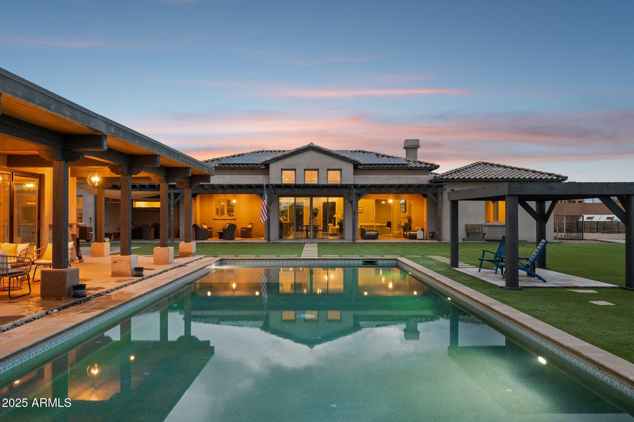Privacy, Desert Luxury, and True Resort Living. Welcome to The Montgomery Compound.

This privately gated two-acre estate offers a 6,384 square foot main home, a 1,576 square foot pool house, and a full casita, creating one of the most complete and expansive residential compounds in Arizona.

Designed for grand living and effortless entertaining, the property blends modern interior luxury with the full experience of a private resort.

The entrance begins with an enclosed courtyard that feels like its own destination. Multiple seating areas surround the outdoor kitchen, media wall, and fire features, creating a warm and welcoming space to gather day or night.

Inside the main home, ceilings rise above a modern living area anchored by a stunning floor-to-ceiling fireplace. The gourmet kitchen is a true showpiece, built around two sixteen-foot islands and extensive custom cabinetry with interior pull-outs, appliance storage, and a complete coffee and wine bar.

The walk-in pantry measures eighteen feet by six feet and includes an oversized side-by-side refrigerator with floor-to-ceiling organization.

Three additional great rooms offer flexible space for media, fitness, or work. The split primary suite overlooks the backyard and features massive closets, a hidden office, and a luxury spa bathroom. Three more en-suite bedrooms and a five-car garage complete the interior.

The backyard is completely private and designed for experiences that feel endless. A sparkling pool sits at the center, surrounded by a greenhouse, fruit trees, sun deck, pergola, fire features, a sport court, and generous open space across the two-acre setting.

The expansive pool house adds another level of versatility. It includes a full kitchen with refrigeration, a large gathering room for games and entertaining, built-in storage, and a beautiful bathroom. One wing is currently used as an art studio and can be adapted to any lifestyle need.

The Montgomery Compound offers resort-style living, complete privacy, and purposeful design at every turn. Properties of this scale and quality are exceptionally rare. Come experience luxury living at its finest.