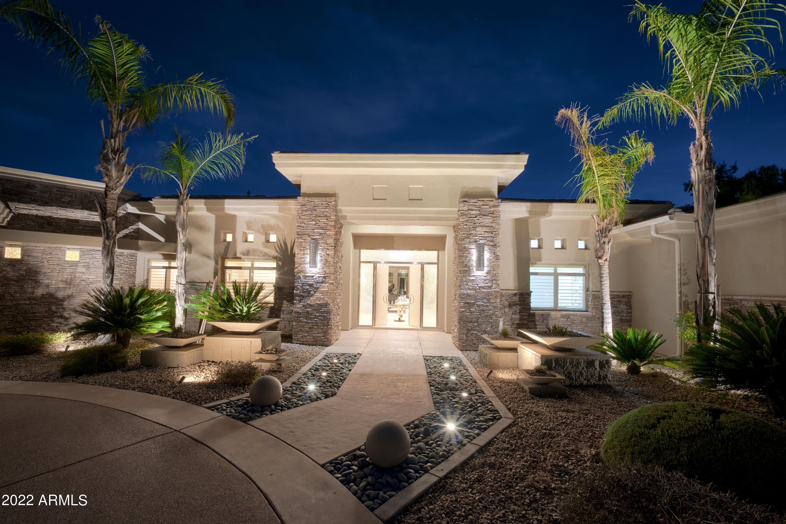 Soft contemporary on quiet end of highly sought-after Sunnyvale. 5car Garage with room to add more. No HOA. Barely lived in Move In TODAY. Split Open Plan wraps around pool. Spectacular craftsmanship, stunning cabinetry, multi-tiered & lighted coffered ceilings to 18 feet, blue & black pearl iridescent granite, imported black onyx, Montana white stone.  Privately gated lush resort acre w/heated pool & spa, dancing water features, mature palm & fruit trees, grassy yard, Pool bath. 28 feet of retractable glass walls to nearly 2,000 sq ft of covered patios, outdoor kitchen & pool Ramada. OPEN Gourmet Kitchen: gas, stainless, 2 refrig drawers, wine chiller, 2 dishwashers, large island w/2nd sink facing yard & Family room with full bar, fireplace & Adjacent Poolside Game Room open to Pool. Split floorplan: The Executive Office and large Owner's Suite each feature double doors with custom cast glass inlays. Owner enjoys breakfast bar, 2-sided fireplace, spa bath with oversized double entry all marble shower, heated floors & towel bars, two large walk in closets (one closet prepped for washer & dryer), gorgeous cabinetry with linen closets and off-season storage, secondary office (or gym or nursery). Motorized shades inside, with electric metal shades outside. Energy Efficient: Solar panels (owned) concealed within the south facing roof tiles have negated any recent electric bills. Double insulated attic, 6" walls, 2 recirculation pumps, commercial misting system, North-South exposure, LED lighting. Wired for sound system throughout the house. Wired for exterior security cameras. The best part of PV:  Walk along the golf course, or grab a coffee at Gainey Village Shops.