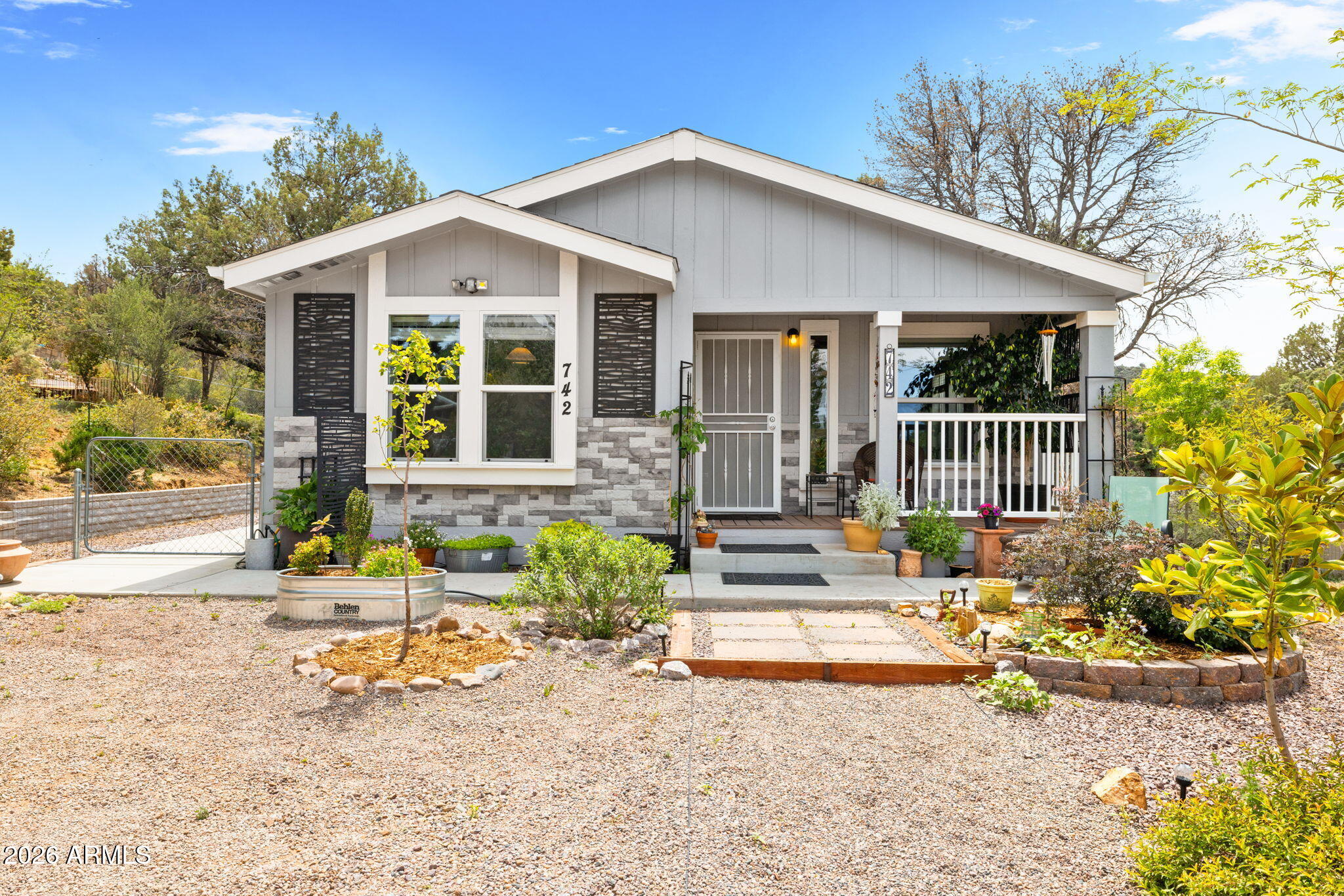 Nestled just six miles from the heart of historic downtown Prescott, this turnkey contemporary residence offers a sophisticated blend of modern comfort and rural serenity. Positioned on a sprawling, elevated lot, the property provides expansive flat, usable land--a rare find in the area--offering endless potential for customization. The inviting interior is defined by a bright, open-concept design featuring vaulted ceilings and premium luxury laminate flooring. At the heart of the home, the gourmet kitchen showcases high-end cabinetry, sleek stainless steel appliances, and a functional center island perfect for gathering. Designed for both refinement and utility, the layout includes three spacious bedrooms and two bathrooms, complemented by a dedicated laundry room. Outdoor enthusiasts will appreciate the previously surveyed grounds, featuring a fenced front yard and ample space for RV parking. With no HOA restrictions, this meticulously maintained home delivers an articulate balance of privacy and city convenience.