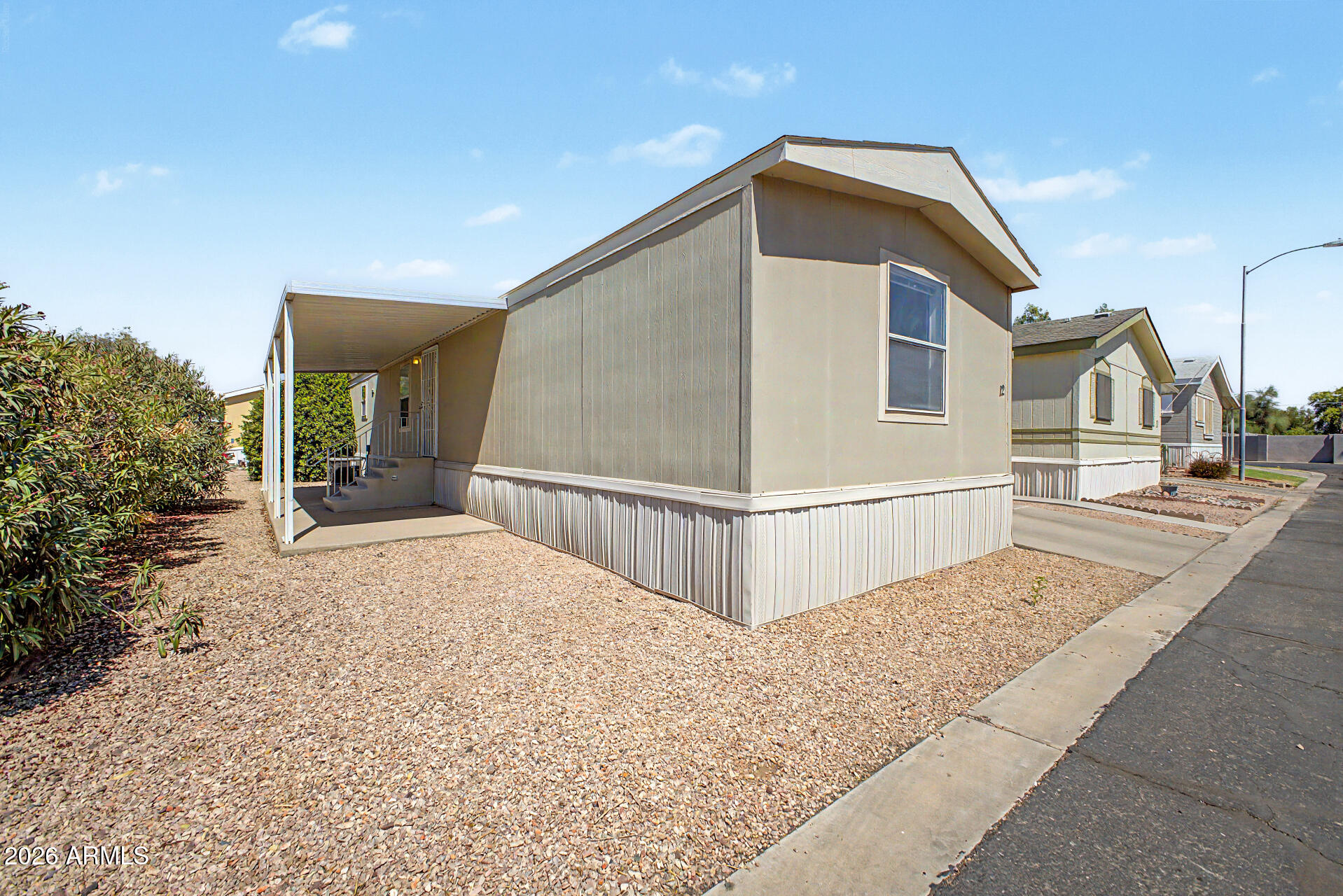 Welcome to this beautifully maintained manufactured home in the heart of Litchfield Park! Freshly painted and meticulously cared for, this home offers a functional open layout filled with natural light. The kitchen flows seamlessly into the living and dining areas, ideal for everyday living and entertaining. Featuring 3 bedrooms and 2 full baths, plus a newer water heater for added peace of mind. Enjoy a low-maintenance lifestyle with access to a clubhouse, pool, gym, and greenbelt. Lot rent includes trash, recycle, and septic. Small pets allowed. Washer, dryer, and refrigerator convey.