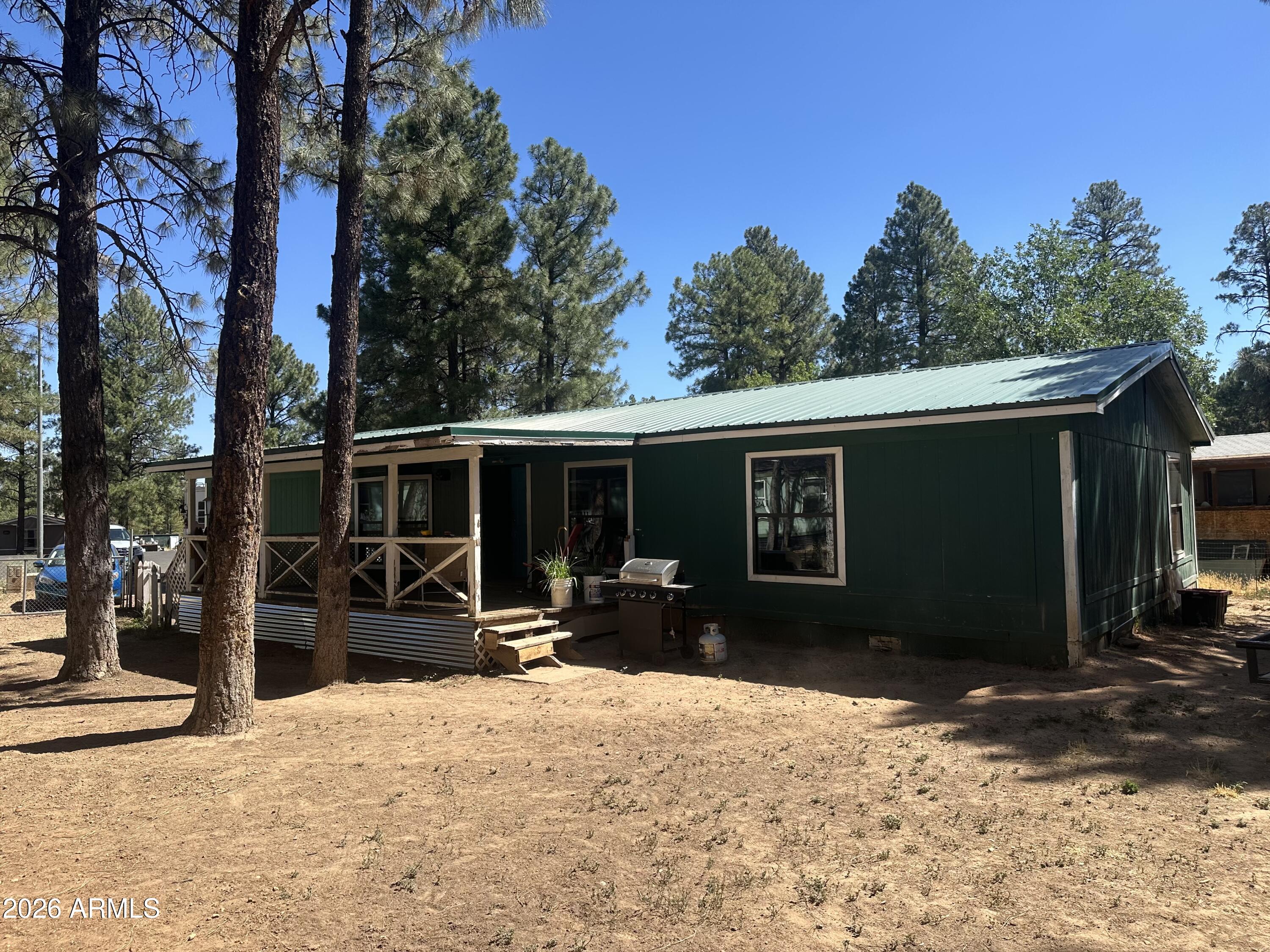 Enjoy mountain living in this 4-bedroom, 2-bath manufactured home located on a quiet cul-de-sac in the heart of Show Low. Nestled among tall pines with mature fruit trees, this fully fenced, pet-friendly property offers privacy and room to enjoy the outdoors. Relax on the covered front porch and appreciate the durability of the metal roof. Currently under renovation, this home presents a great opportunity to add your own finishing touches and build equity. Convenient in-town location close to shopping, schools, restaurants, and recreation. Don't miss this chance to own an affordable home in the beautiful White Mountains!