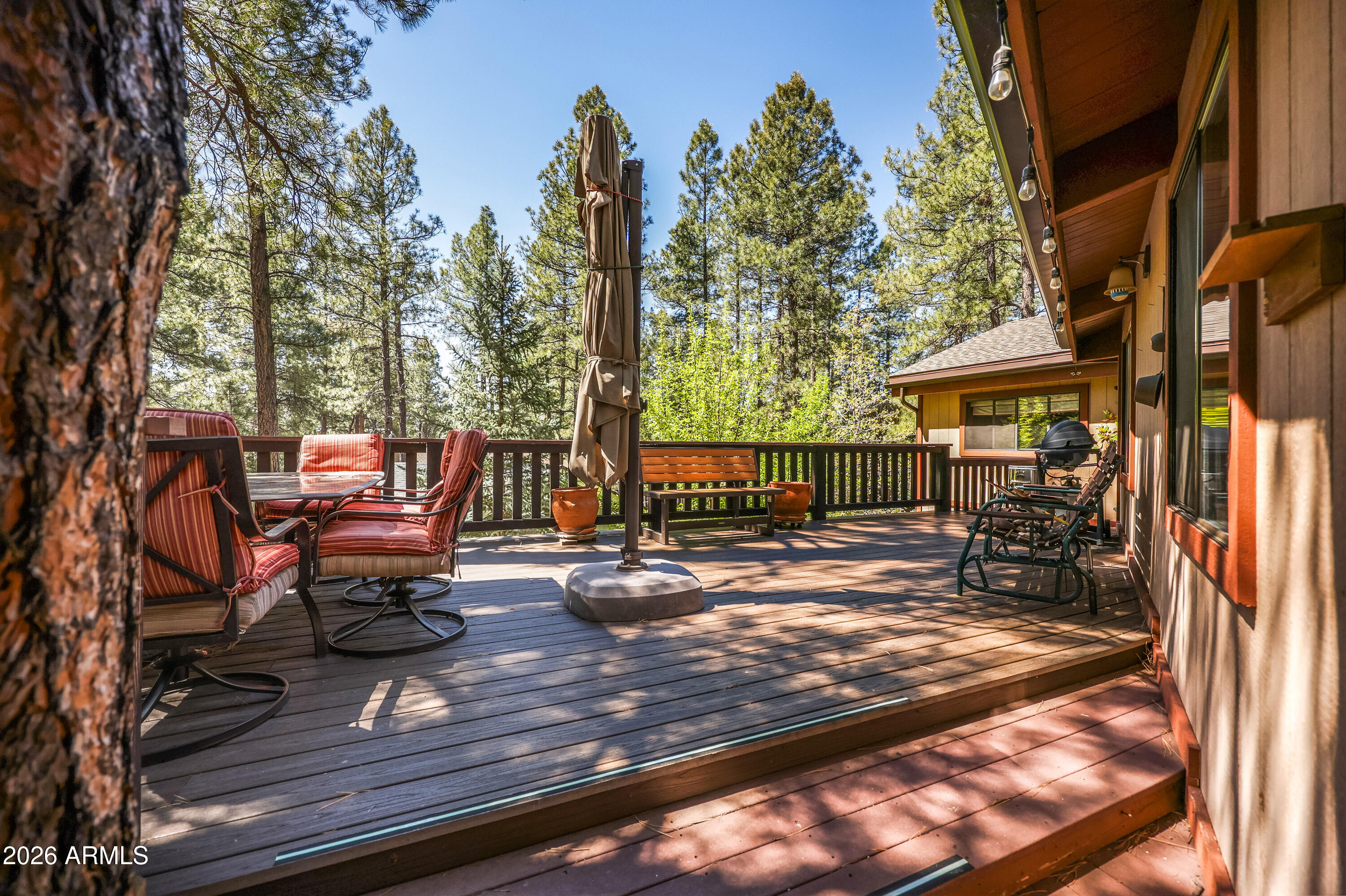 If you're looking for a cozy, fully furnished 4-bedroom cabin with a large bonus room in the wonderful community of Munds Park, you won't want to miss this one! Nestled on a private cul-de-sac among the cool pines, this charming mountain retreat offers warmth, character, and room for everyone. Originally built in 1975 with 1,384 sq ft, the home was thoughtfully expanded in 2007 with an additional 862 sq ft, creating spacious and versatile living areas ideal for family and guests. (County adjusted year built to 1988) The  inviting interior showcases beautiful custom pine tongue-and-groove throughout, with matching ceilings and walls that create a warm and authentic cabin feel. The remodeled kitchen features upgraded cabinetry, countertops, dishwasher, and attractive wood flooring extending through the kitchen, hallway, and upstairs bathrooms. The downstairs addition includes a private bedroom, bathroom with jacuzzi tub, laundry room, and an expansive bonus room -- perfect for guests, kids, game room, or multi-generational living. A separate furnace serves the downstairs area for added comfort and efficiency. Upstairs bathrooms have also been updated with a newer tub and walk-in shower.

Owners have added a garage, concrete driveway, enlarged front porch, and a spacious deck built above the garage -- the perfect place to relax, unwind, and entertain in the peaceful mountain setting. Additional improvements include a newer roof installed in 2020. There are two separate driveways as well as the garage for your guests and vehicles.
Located within walking distance of Pinewood Country Club, this home offers easy access to golf, pickleball, tennis, national forest, lake, hiking and biking trails, UTV trails, playground, restaurants, bars, convenience store, NiMarco's Pizza, and more!
Just 17 miles south of Flagstaff and only about two hours from Phoenix, Munds Park is the perfect escape from the desert heat. Come see your new home in our neck of the woods!