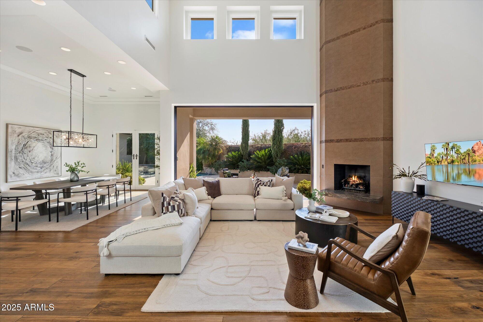 Experience refined luxury in a residence where architectural distinction meets effortless sophistication. Nestled in a most coveted, guard gated enclave, Paradise Reserve, this home is more than a luxury residence, it's a personal retreat for the sophisticated buyer. Every detail has been curated to balance style, comfort, convenience, and resort-caliber living. Dramatic, vaulted 22' ceilings, vast windows, a floor-to-ceiling fireplace, hardwood floors, and retractable glass wall flood the open living spaces with light, creating a seamless connection to the outdoors. The chef's kitchen is a statement of beauty, form and function, featuring Wolf & Sub Zero appliances, dual quartz islands, custom cabinetry, two spacious walk-in pantries and a dedicated elevator-ready area.

The main-level primary suite is a true sanctuary, offering a private patio, boutique-style closet, spa-inspired bath, and an additional main-floor office or bedroom with French doors. Beautiful, spacious upper level includes beautiful flex space, two bedrooms with Camelback Mountain and city view light patios. A detached private casita with its own garage completes this refined, luxury property.

Step outside to your personal oasis. Designed for year-round enjoyment, this space flows seamlessly through an electric retractable glass wall, where lush, low-maintenance landscaping surrounds a dramatic, sparkling, heated pool and spa, tranquil water feature, built-in BBQ, and multiple patios, perfect for entertaining or reflection under the Arizona desert sky. This home is just minutes from Scottsdale, Arcadia & Biltmore Area shopping, dining, resorts, golf, & hiking. It provides easy access to the 51, Sky Harbor Airport, Downtown & the Camelback Corridor. This is truly Paradise found at an incredible value and lock and leave convenience.