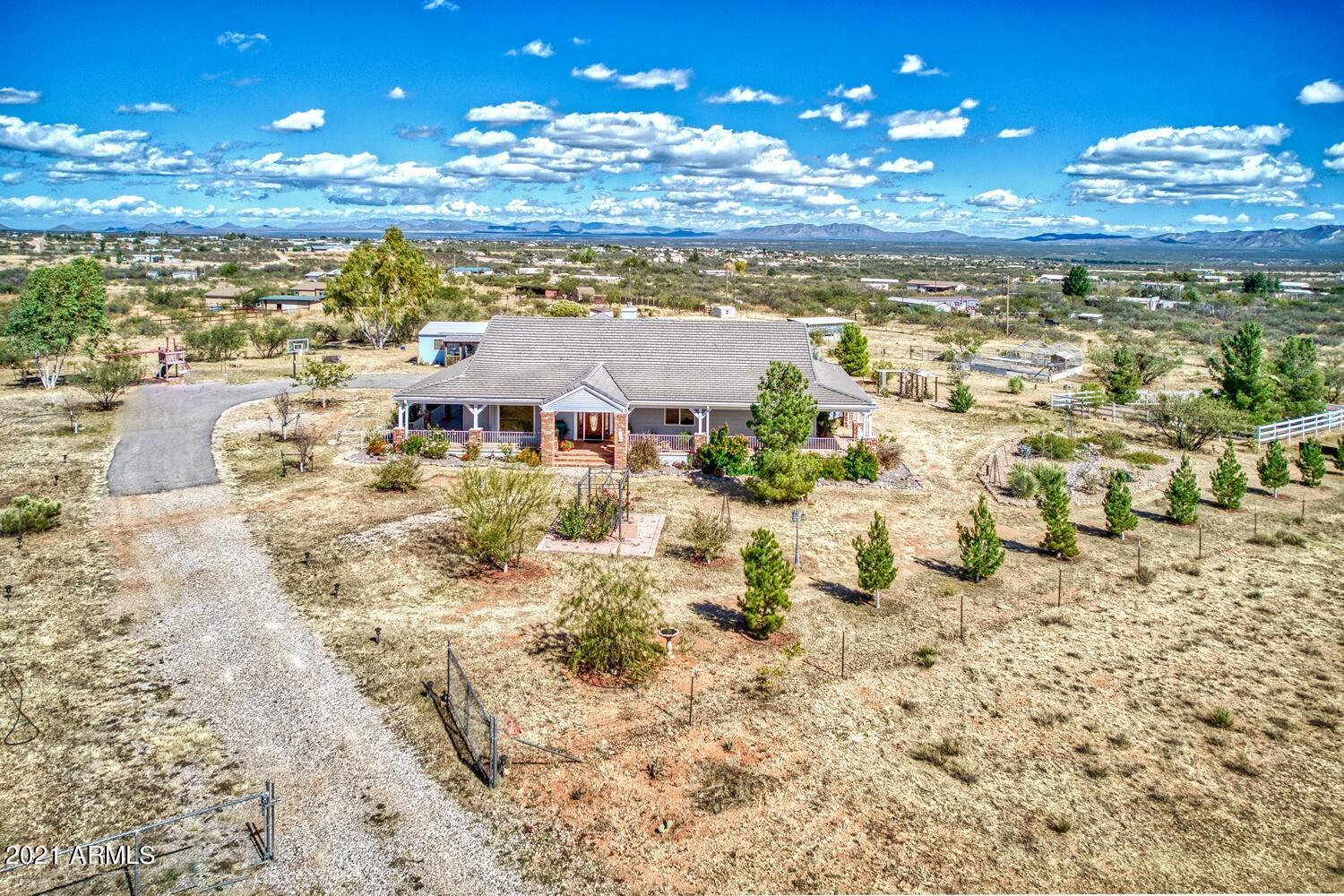 Upon arrival you'll notice the inviting wrap around deck perfect to appreciate Mtn Views & AZ colorful sunrises & sunsets. Land is fully fenced & has a pond, children's playset, multiple areas for farm animals & a workshop w electricity & 1/2 bath, could be converted to a casita or use for anything that fits your lifestyle. You'll love the spacious & bright open kitchen, dining, living room space, a double fireplace that divides living room and family room, master bedroom with its own fireplace & walk in closet, master bath w jetted tub & walk in shower,3 additional bedrooms & 2 baths for a total of 4 bedrooms & 3 baths, ample laundry room and large pantry. Central vac, speakers inside & deck area are some extras. XL 2 car garage with plenty of storage completes this wonderful custom home