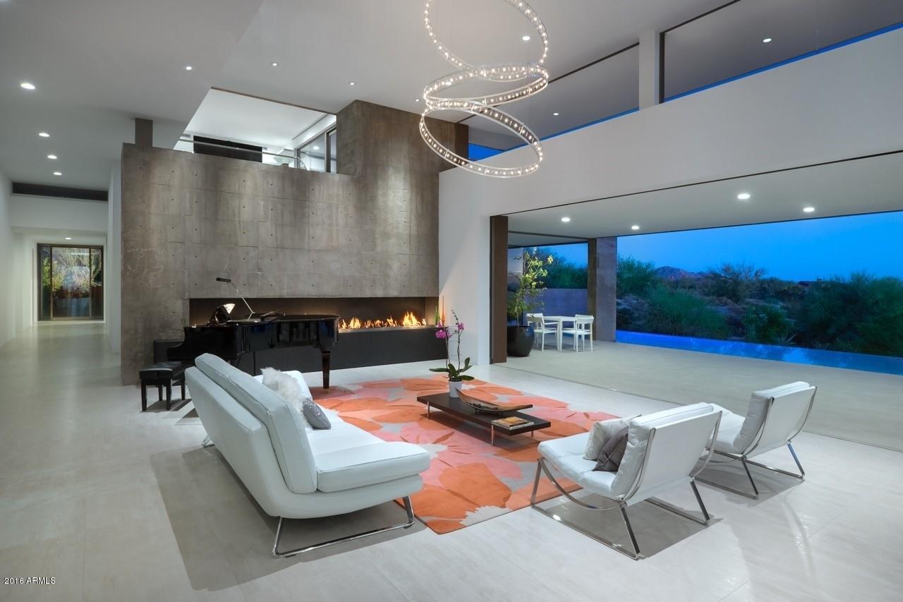 This modern and recently built custom contemporary home is for the buyer that will accept only the finest of materials and finishes.Home is located on the 17th fairway in the exclusive guard gated community of Mirabel Golf Club and boasts breathtaking mountain,city light and sunset views.The designer kitchen is an entertainer and chef's dream with Bulthaup custom cabinetry,Caesarstone countertops and top of the line Miele stainless steel appliances.Kitchen flows seamlessly into living room with a dramatic polished Basalt 14ft linear fireplace.Luxury sliding pocket door system brings the outdoors in.Spacious covered patio contains a master grill station and overlooks the negative edge heated pool/spa with golf course views. Master bath is spa inspired with European style dual rain shower... system with linear tile shower drain. One-of-kind custom floor to ceiling glass window seamlessly continues up to the roof and over to become a dramatic full length ceiling skylight. Wetstyle bathtub sits atop black spa rocks. His and hers Wetstyle dual sink cabinets and wall mounted mirror vanity cabinets. Heated floor and ceiling heaters. Top of the line Kohler NUMI touch screen remote control toilet. All tile inc flooring is Italian.
Master bedroom has imported polished Basalt linear gas flame fireplace, sleek black bamboo floors, sitting area, separate entrance to pool patio, electronic privacy screens and walk-in closet.
2nd and 3rd bedrooms are identical with full en-suite baths with Italian tile, rain shower, walk in closets, black bamboo flooring, privacy window screens and custom bamboo doors.
Fourth bedroom is used as an art studio and has full en-suite bath with Italian tile, rain shower and walk in closet. Beautiful custom made contemporary sliding barn entrance door and polished colored concrete flooring.
Dedicated den/study has view of private Zen meditation garden with imported Basalt water fountain. Light and bright with recessed LED lighting, custom self closing cabinets, custom floating wall display shelving and Italian tile floor.
Indoor atrium has serene bamboo garden with quartz surround sitting bench.
Home entryway will greet your guest with an outdoor Zen water feature and an art inspired custom made 9x9 foot front door with 9x7 foot double-sided etched tempered glass insert and Italian tile flooring both inside and out. 
Powder room is striking and has a custom made white tempered glass sliding door. Dramatic floor to ceiling glass wall tile on main wall with other walls boasting Sasso white Italian tile. Italian handcrafted hanging LED pendant light fixture (matches kitchen) with Wetsyle cabinet and vanity. Dubarit modern wall hung toilet. Built in paper towel dispenser and garbage receptacle is perfect for entertaining large groups. 
Exercise/fitness room has poolside and golf course views with separate entrance to pool patio. Sleek black bamboo flooring, custom floating shelves, contemporary ceiling fan, sun shades and custom bamboo door.
Poolside bath is shared with exercise room and has separate entrance to pool. This luxurious full bath has both steam and regular shower with rain shower head and a quartz sitting bench, Italian tile, Toto toilet and Wetstyle cabinet and vanity. 
Dramatic floating staircase is cantilevered from the cast-in-place concrete wall with a glass and stainless steel handrail and black satin hardwood stairs.
IMPORTANT TO NOTE-All necessary living spaces inc all bedrooms are on the main 1st floor.  The 2nd floor ONLY contains the observation deck and the bonus wet bar/media family room with powder room.
2nd floor media family room has stunning vista views of sunset, mountain, city light and golf course views.  Tastefully accented with white bamboo flooring and impressive wet bar area for entertaining with electronic privacy shades..  Wet bar area includes a Bulthaup (6x4ft) two door bar storage organizer.  Bar top sitting area is also all Bulthaup inc the countertop, cabinet, trash receptacle and faucet.  Top of the line Liebherr bar refrigerator with separate freezer and a Kinetico drinking water system add to the luxury and convenience of entertaining on the 2nd floor.
Conveniently located 2nd floor powder room has glass wall tile, Wetstyle cabinet and vanity along with Toto toilet and custom bamboo pocket door. 
The 2nd floor observation deck is a jewel.  Enjoy a beverage while taking in the massive views of the golf course, mountains, city lights and sunset. Sit fireside next to a top of the line Paloform modern, rectangular, concrete outdoor linear gas burning fireplace. Watch as your negative edge pool lights playfully change colors. Dramatic deck lighting and outdoor speakers top off the moment.  Deck also boast grooved Italian flooring and a glass and steel railing.
Garage is 3 car and oversized with custom storage cabinets. epoxy flooring, state of the art Liftmaster wall mounted garage door openers and exterior pleasing copper garage doors with custom made outdoor sconces .
Laundry room is beautiful, light and bright with skylights, custom made frosted glass and aluminum upper cabinets in addition to custom soft touch cabinetry for extra storage. Caesarstone countertops, Italian tile floor and custom bamboo door finish the clean look. Sale will inc the state of the art LG washer and dryer.
Please print off the FEATURE SHEET found in the DOCUMENTS tab for more details esp regarding the kitchen amenities such as the custom Bulthaup cabinets, Caesarstone countertops, and the top of the line Miele appliances inc the speed oven, regular oven, steam oven, warmer drawer, 6 burner gas range cooktop, espresso/coffee system, s/s dishwasher. Italian handcrafted hanging LED pendant light fixture and Thermador refrigerator and separate freezer along with the Sub Zero wine refrigerator will all convey. 
Much more to be impressed with regarding the quality and attention to details this home delivers.  If you are looking for a tasteful, modern and contemporary home constructed to the highest standards with unbelievable desert and golf course views this is it!