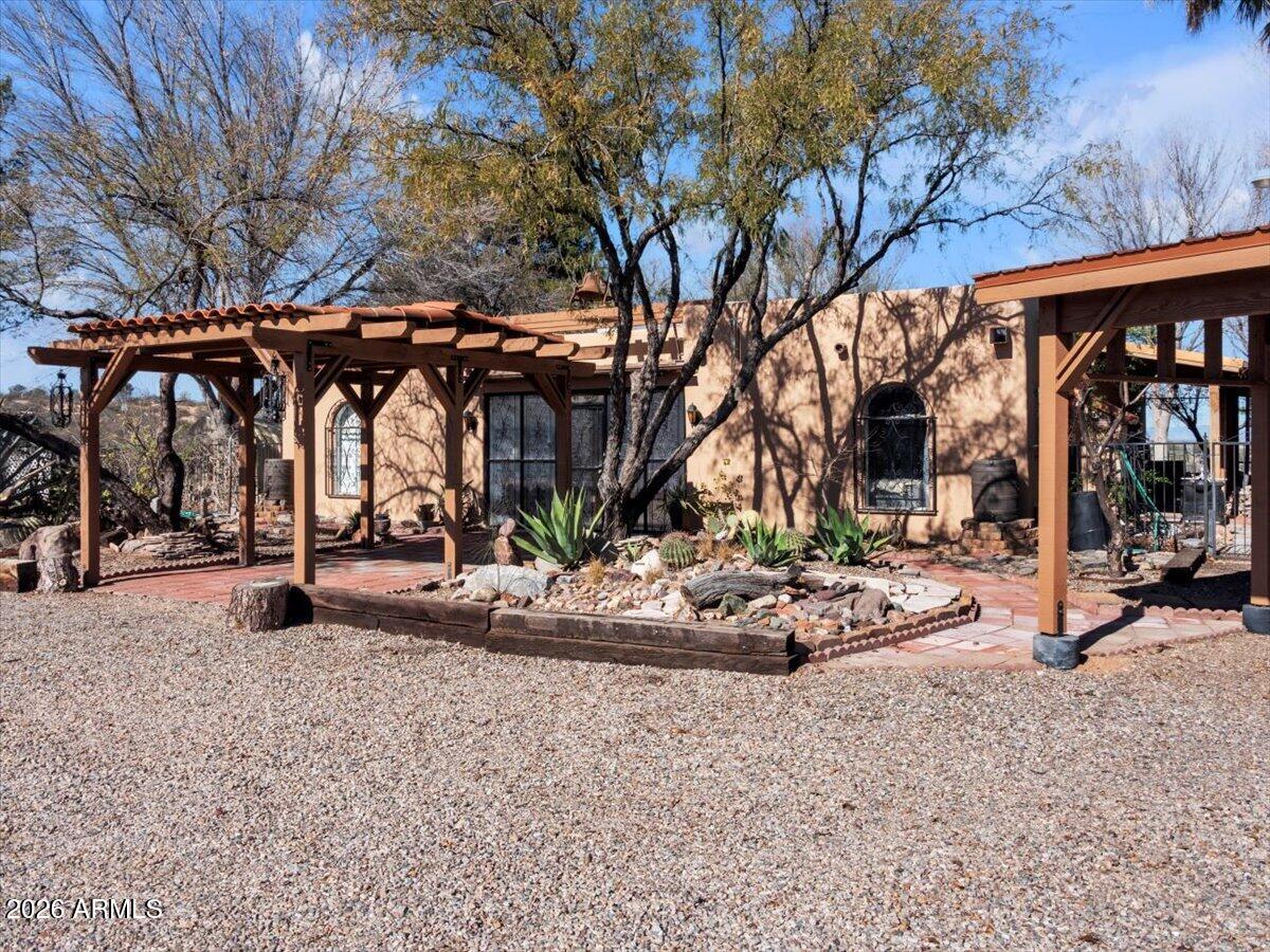 Set on approximately three acres, this private retreat offers open skies, expansive 360° mountain views, and a serene, natural setting. The home features a sunken living room with generous gathering space and a cozy fireplace, along with a large kitchen finished with travertine countertops. Outdoors is a true oasis, beautifully shaded by mature trees that transform with the seasons. Enjoy abundant fruit trees, productive garden beds, and a private sauna for year-round relaxation. With exceptional privacy, storage, and versatility, this rare property is perfectly suited as a residence, retreat, or investment.