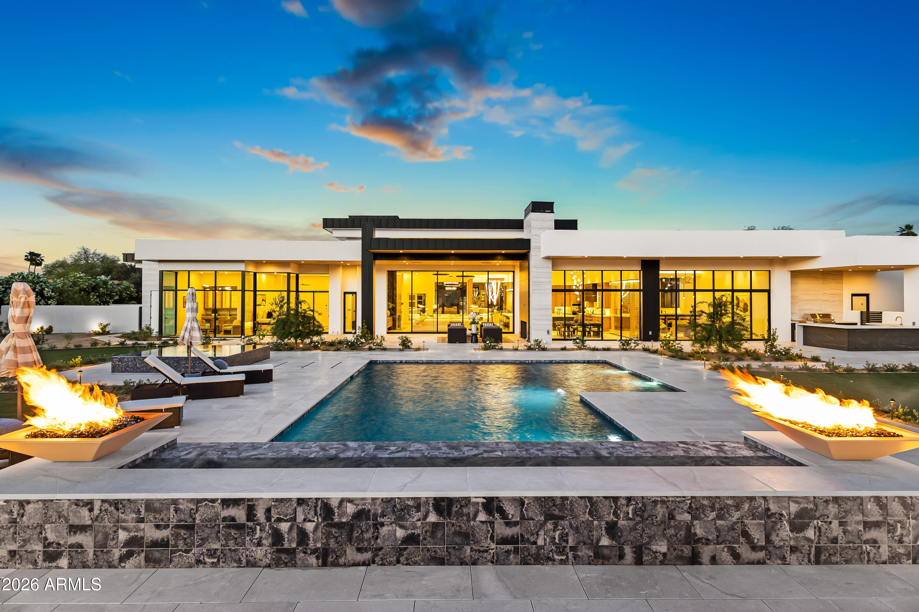 Newly completed architectural masterpiece showcasing breathtaking Mummy Mountain views in the heart of Paradise Valley. Situated on an expansive 1+ acre lot within the prestigious Camelback Country Club Estates, this exceptional single-level estate offers refined desert luxury and seamless indoor-outdoor living. The main residence features 4 spacious bedrooms and 6 spa-inspired bathrooms, complemented by a private 1 bed/1 bath guest casita complete with its own kitchen and living area--ideal for guests or multigenerational living. Designed for both grand entertaining and everyday comfort, the open-concept floor plan includes a stunning great room, formal dining area, and elegant living room anchored by a dramatic marble fireplace. The chef's kitchen is a true centerpiece, featuring dual oversized islands, a breakfast nook, and a fully equipped butler's pantry. The luxurious primary suite offers a private sitting area, direct access to a serene courtyard, an adjoining fitness room, and a spa-like bath with an expansive walk-in closet complete with in-suite laundry. Resort-style outdoor living includes a custom heated pool and spa, outdoor fireplace, fully equipped kitchen with island, and multiple lounge and entertaining spaces surrounded by mountain views. Additional highlights include a private office with custom built-ins, a game room with a striking glass wine wall and full wet bar, and a 4-car garage. Ideally located just minutes from top-rated schools, world-class resorts, fine dining, upscale shopping, and entertainment.