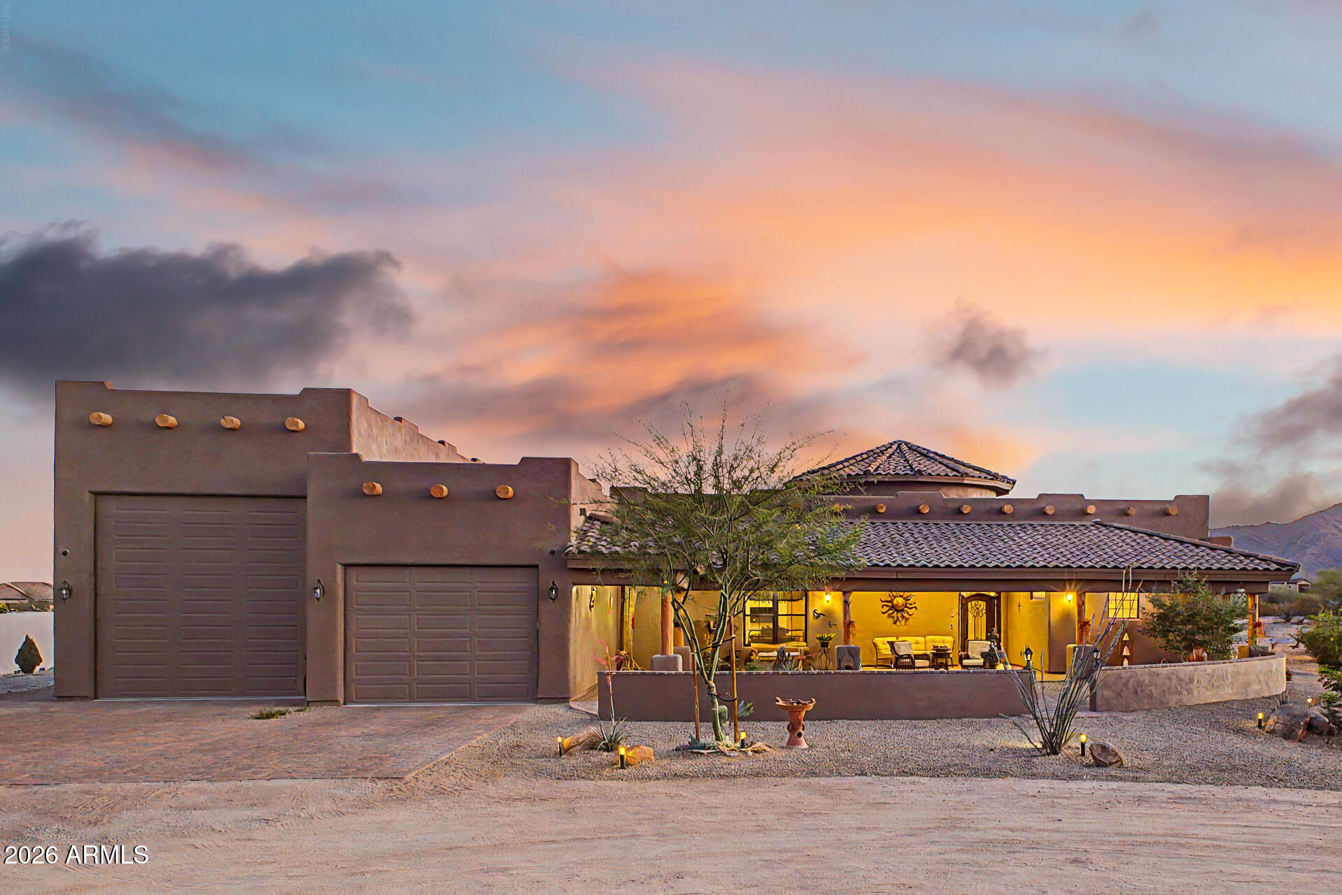 Custom home on ¾+ acre in desirable gated Sonoran Ridge Estates. Open layout with 10' ceilings, gourmet kitchen, 15' vaulted living room, & oversized windows showcasing mountain & sunset views. Features dual primary suites with en-suite baths, walk-in closets & patio access, plus a versatile third bedroom/office. Enjoy outdoor living with covered patios, built-in BBQ & front courtyard water feature. 48' RV garage with full hookups offers exceptional space for RVs, boats, luxury vehicles, or workshop. Located just minutes from White Tank Mountain Regional Park, you'll enjoy easy access to hiking, biking, and year-round sunshine--while still being within reach of city conveniences. This home is the ideal blend of comfort, privacy & outdoor lifestyle.