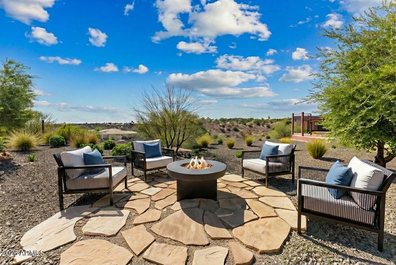 Located in the sought-after community of Wickenburg Ranch, this beautifully designed 2-bed, 2-bath home offers 1,549 square feet of comfortable, stylish living. The open floor plan features a spacious living area with a striking statement wall and abundant natural light from large windows. The kitchen is ideal for entertaining, complete with a generous island, modern finishes, and ample storage. Wood-look tile flows throughout the main living spaces, adding warmth and durability. Step outside to enjoy the large covered patio, perfect for relaxing or gathering around the firepit. Low-maintenance desert landscaping surrounds the home, making outdoor living effortless. A 2-car garage completes this move-in ready home in one of Arizona's premier lifestyle communities.