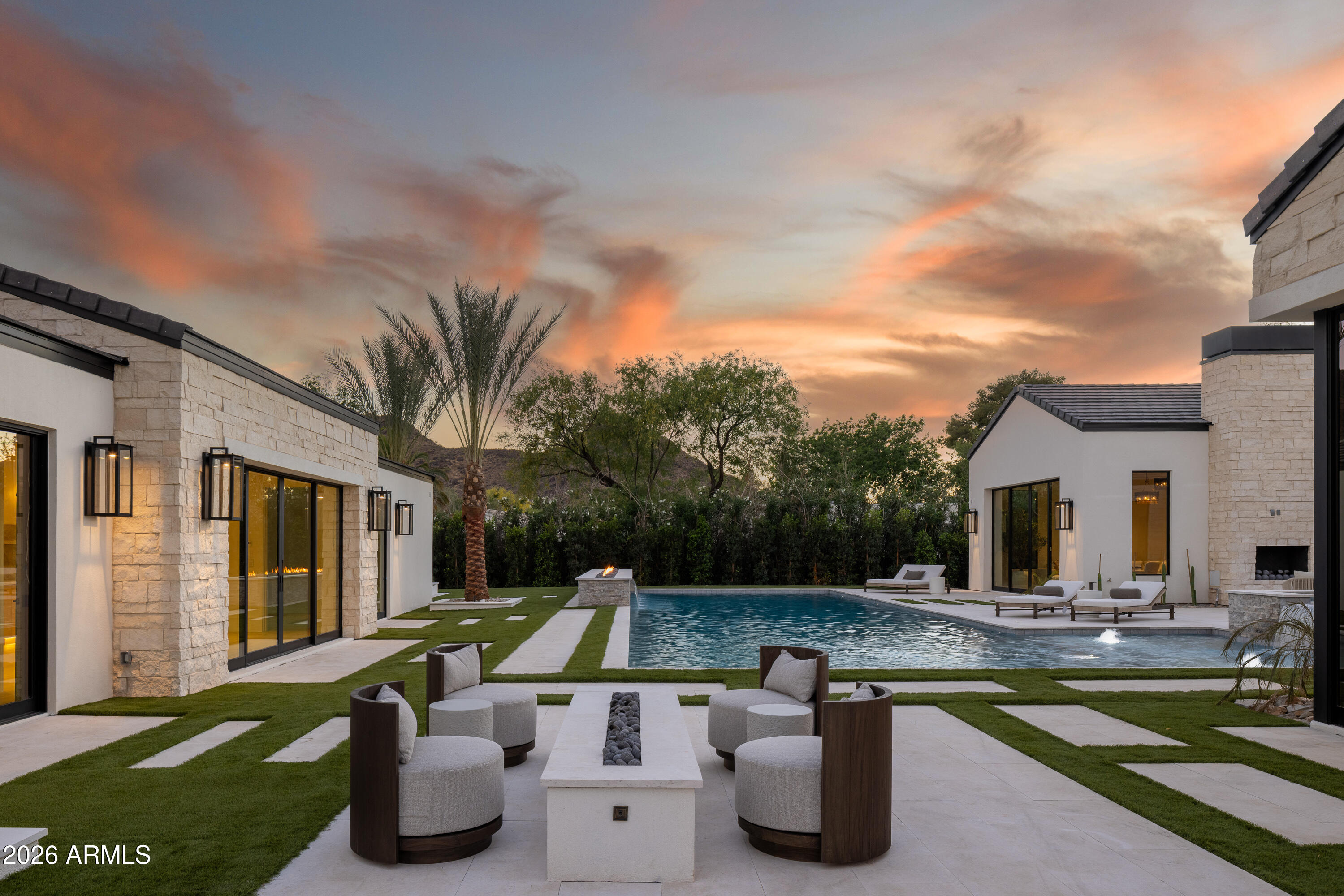 Set on a quiet cul-de-sac in the heart of Paradise Valley, this custom estate offers a true split floor plan with refined architecture and thoughtfully curated interiors by London Pierce Design. The main living space is defined by vaulted gable detailing with dormer light, rift white oak cabinets, a custom fireplace, and a full western door system that opens seamlessly to the backyard. The chef's kitchen features barrel-vaulted ceilings with custom lighting, dual stone islands, bespoke cabinetry, Wolf + SubZero appliances, and an exceptional oversized scullery. Arched hallways finished in Roman clay add depth and continuity throughout. Entertaining spaces include a formal dining room with a custom wine wall, plus a morning room that opens directly to the outdoor kitchen. Additional interior amenities include a dedicated office, a glass-lined workout room, and a large game room with direct access to the pool and outdoor living areas.

The private primary wing features a spa-quality bath with dual vanities, a soaking tub, and an oversized walk-in shower, along with separate his-and-hers closets, dual water closets, and a secondary laundry. On the opposite wing, secondary en-suite bedrooms are thoughtfully positioned for privacy. Outdoor living is anchored by a covered patio, large pool and spa, and a private pickleball court. Lastly, a detached two bedroom, two bathroom guest house with its own living area and kitchenette adds flexibility for guests or extended stays or multi-generational living.
