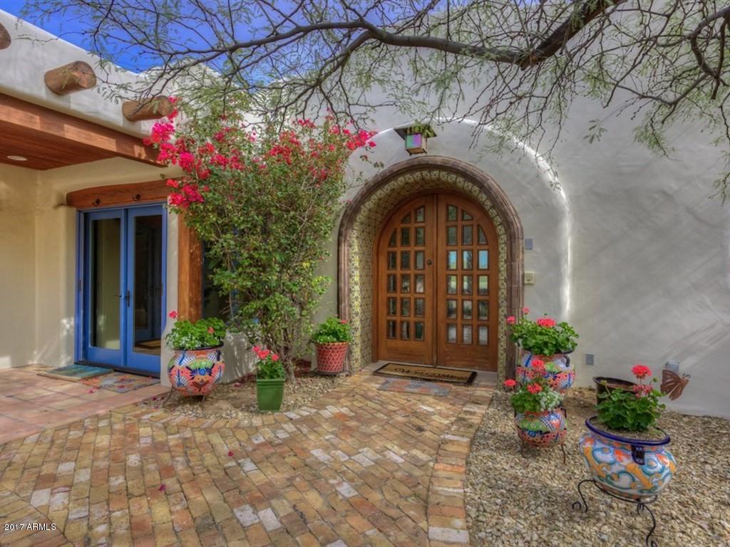 As you enter through the gracious foyer of this classic adobe estate, you’ll know you’ve arrived someplace very special. Each room has its own distinct flair and beautiful southwest style. The double island kitchen is gorgeous, the breakfast room is surrounded by picture windows that perfectly frame the stunning views, the dining room is loaded with elegance and warmth, both the living room and family room are exquisite, all the bedrooms and baths have unique design elements, and there’s a bonus room that is sure to impress anyone who sees it. The home’s stylish finishes include gorgeous wood flooring, brick barrel ceilings, exposed beams, outstanding custom tile designs, dramatic lighting, five impressive fireplaces, and fabulous custom cabinetry. The setting and atmosphere is extraordinary with views that will take your breath away!
