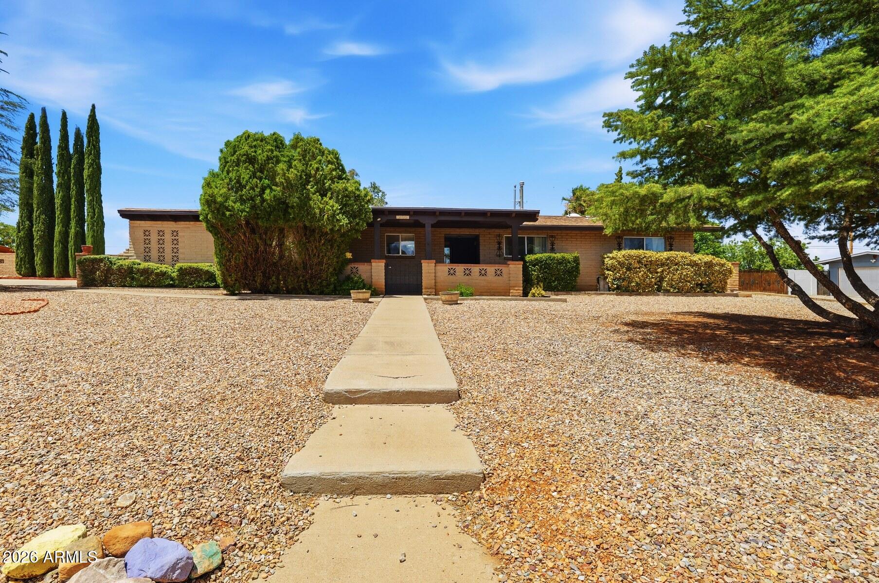 Beautifully updated 3BR/2BA home offering 2121 sf on a spacious .446-acre lot! Enjoy a covered front porch, two living areas, formal dining, and a cozy fireplace in this inviting great room floorplan. The remodeled kitchen features white wood cabinetry, granite countertops, pantry space and a bright, airy feel. Spacious primary suite includes  an updated bath with tiled walk-in shower. Full guest bath with subway tile. Large pine-finished Arizona room with skylights is a unique feature that provides additional living space. Outside you'll find huge fenced backyard w/ above-ground pool, grass, RV gate, RV hookup, workshop, multiple storage areas, and plenty of parking. Central A/C, indoor laundry with washer and dryer, 2-car garage, and loads of parking. Close to shopping, dining, and more!