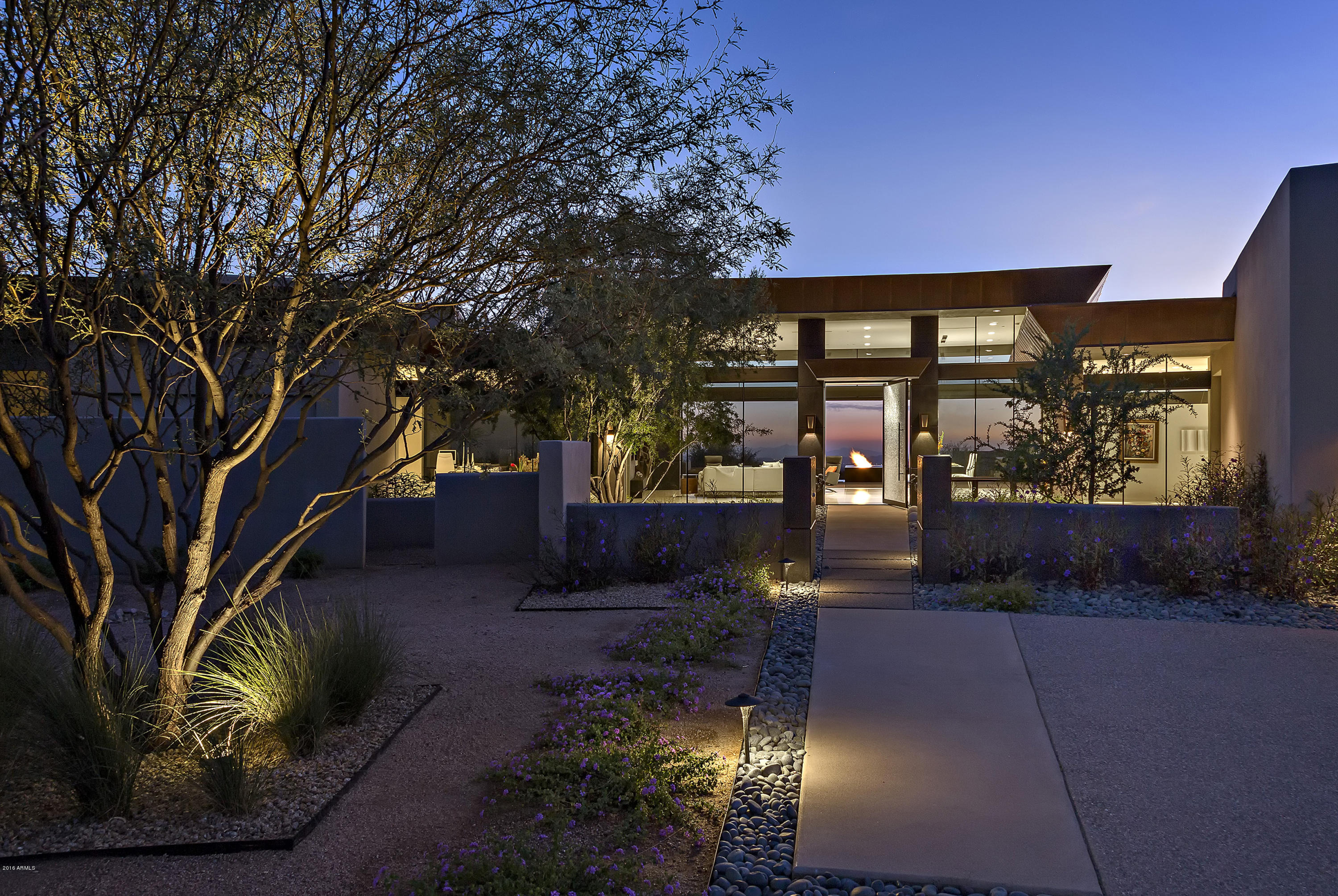 Elegant and refined NEW construction on an elevated lot with panoramic sunset and city light views in Desert Mountain * An architectural statement in the form of a curvilinear design that maximizes the indoor/outdoor living experience *  One-of-a-kind Fleetwood motorized door system completely retracts into the wall creating a 36' seamless flow from the Great Room to the outdoors * Details and materials include an extensive use of glass, steel, copper, black basalt and aggregate stucco textures on the exterior and interior, supplemented with limestone, granite and wood inside * The ideal floor plan with kitchen, dining and great rooms connected as one space * The master suite is split from the guest bedrooms and there are ZERO interior steps * Room to add a guest house with conceptual approval showing location or flexibility to add a 4th bedroom inside the house * The focal point of the outdoors is the heated pool and spa which frame a unique fire & water feature * This property is the epitome of timeless elegance harmonizing with the desert environment in a unique form of complete functionality *