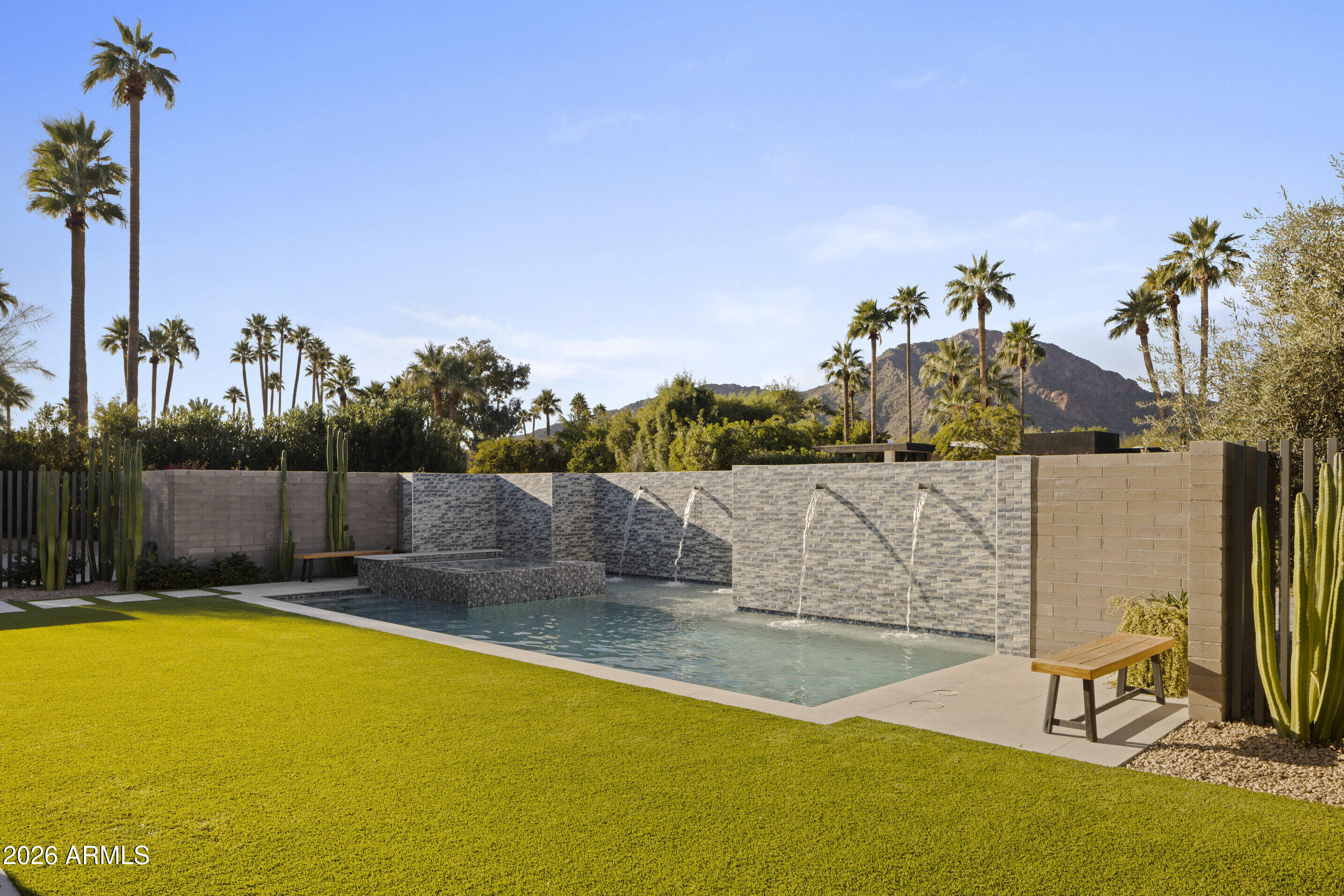 Completely reimagined in 2018, this meticulously updated Paradise Valley estate sits on a QUIET CUL-DE-SAC w/GATED entry on a unique lot capturing CAMELBACK MTN and MUMMY MTN VIEWS. Built to showcase both art and views, the 5,920sqft COMPOUND includes 5,062sqft main residence + REMOTE 1 bd/1.5ba GUEST HOUSE with full livingrm, kitchen, laundry, patio, and 2 garages—accessed by a LONG TREE-LINED DRIVE offering exceptional privacy. The main residence also includes an internal casita w/ private lounge and patio, ideal for 2nd primary, office, or gym. Large pocketing glass walls open to a modern pool + spa. Chef's kitchen, large wine room, manicured desert landscaping, solar w/Tesla battery backup, EV charging, Control4 lighting and AV, + air-conditioned main garage in a premier location.