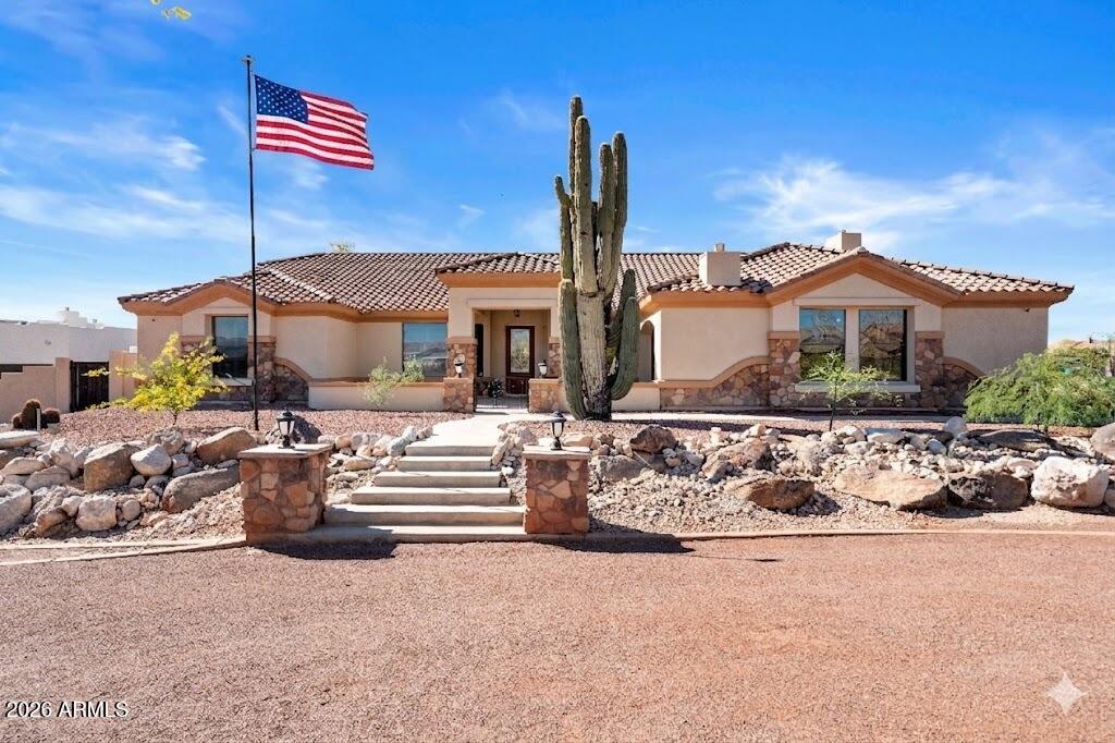 Stunning 4,040 sq. ft. custom home on a 37,410 sq. ft. lot in Litchfield Park offering privacy, elegance, and mountain views. Gated entry, circular driveway and decorative fencing. Open archway entry leads to pride of ownership at every step featuring travertine tile, plantation shutters, and upgraded fixtures. Spacious kitchen with stainless steel appliances, cherry cabinets, granite counters, and island. The split floor plan includes walk-in closets in all bedrooms. Large Primary Suite with sitting area, dual closets, dual sinks, jetted tub, and walk-in shower.  Walk-out basement includes bar, projector/screen, game room, bedroom, and bath. Rooftop balcony for sunset views. Backyard oasis with heated pool/spa and waterfall, built-in BBQ, fire pit, flagstone patio with fireplace and more. Luxurious Custom Home in Litchfield Park with Mountain Views and Resort-Style Backyard.  Stunning 4,040 sq. ft. custom home on a 37,410 sq. ft. lot offering privacy, elegance, and refined desert living. Gated entry with new circular driveway and decorative security fencing creates a grand first impression. Inside, an open archway entry leads to a perfectly placed office, ideal for remote work or a quiet retreat. Interior finishes include travertine tile, plantation shutters, and upgraded fixtures throughout. The spacious open kitchen features stainless steel appliances, cherry cabinetry, granite counters, large island, pantry, and more--perfect for entertaining and everyday living. This split floor plan provides walk-in closets in all bedrooms. The large Primary Suite includes a cozy sitting area, dual walk-in closets, dual sinks, separate shower, and jetted tub for a spa-like retreat. The expansive walk-out basement features a bar, projector and screen, game room, bedroom, and full bath--ideal for hosting guests. A rooftop balcony with spiral staircase captures breathtaking mountain and sunset views. The backyard oasis boasts a heated pool and spa with waterfall, built-in BBQ, fire pit, and extended tile decking. The covered patio includes flagstone flooring, fireplace, ceiling fans, a misting system, and roller shades for year-round comfort.  Additional features include newer HVAC units, sump pump, 4-post car lift, and ample space for your RV and toys. A true Litchfield Park retreat combining luxury, functionality, and Arizona resort-style living--a must see in person!
