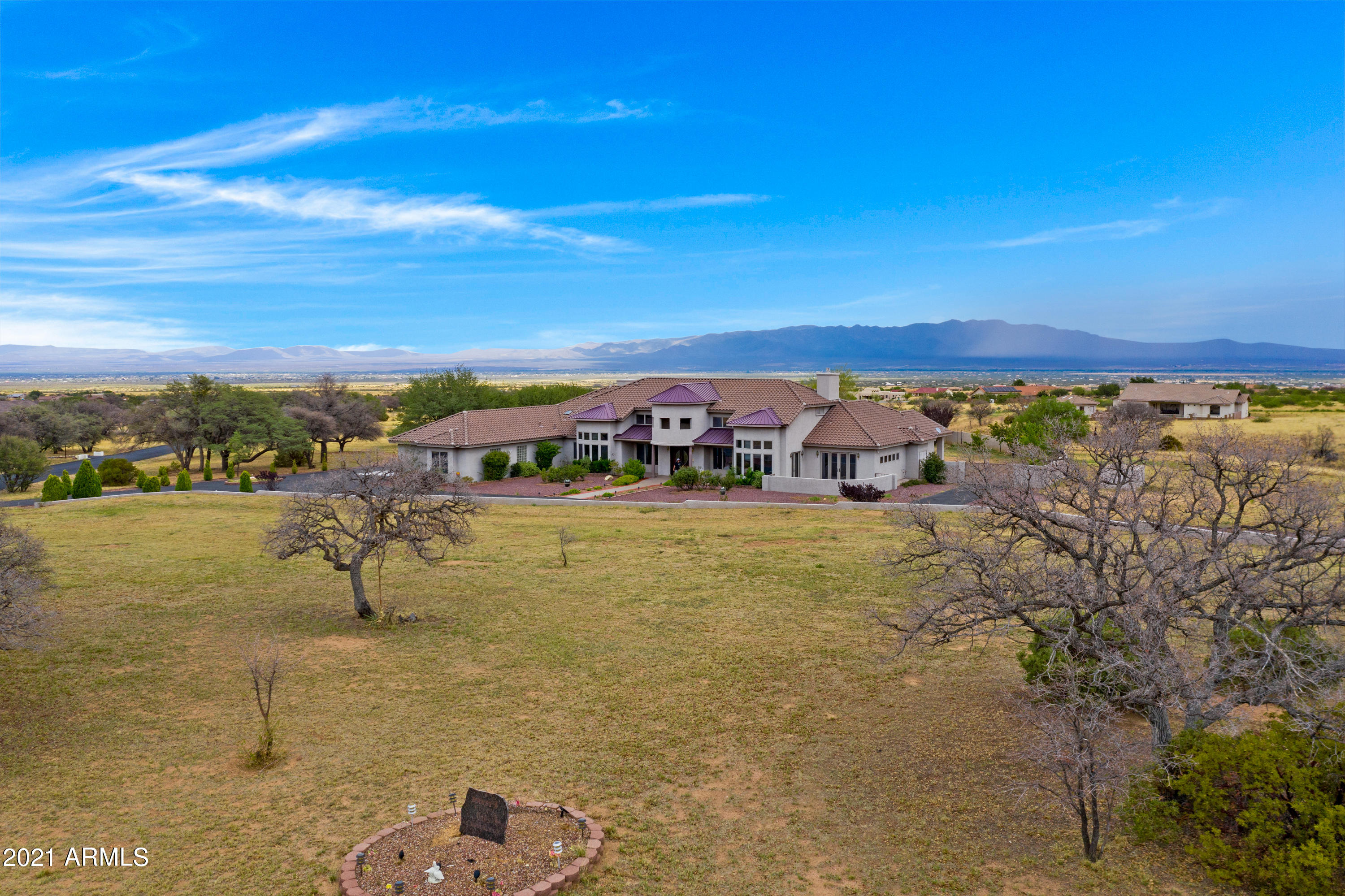 With almost 7,000 sq ft (including AZ room), set in the subdivision of Wild Horse, 360 degree views, you do not want to miss this exquisite, one of a kind home! On nearly 4 acres with a block wall fenced backyard and several different fruit trees lining the wall. Grapes too! Back patio has a built in kitchen, whereas the front patio might just be perfect for a new hot tub! Inside you will find bedrooms with plenty of privacy. The master suite  includes 3 rooms and 2 huge walk in closets. The master bath is a must see. 2 more bedrooms with private entrance on the west side, and another at the back of the home. Granite everywhere! Bar that serves living room and Man Cave/AZ room. Kitchen has 2 pantries and an island. In house vacuum, water softener! too much to mention!