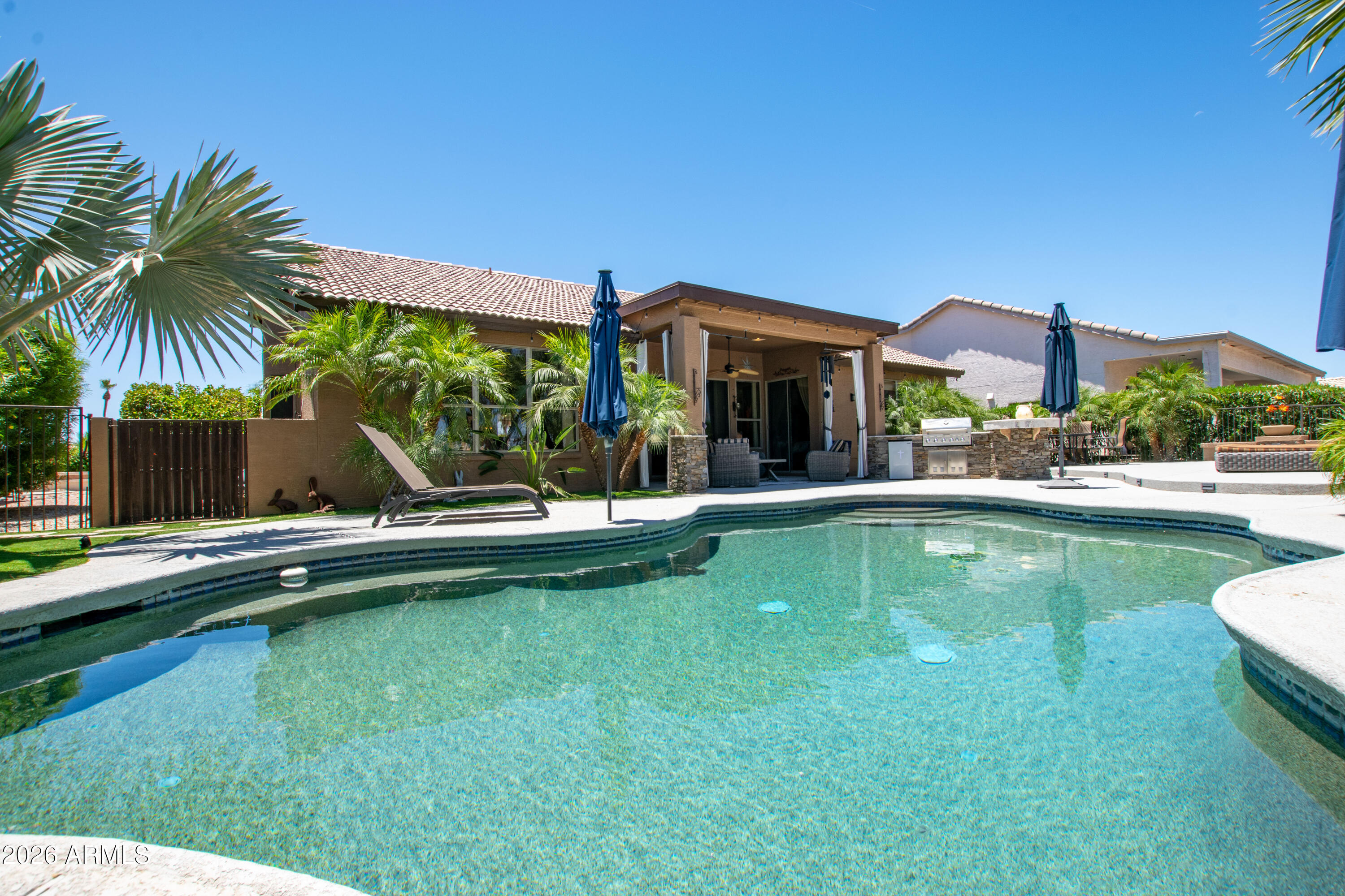 This beautifully updated Estancia model home is perfectly situated on the golf course along Hole 2 of the Eagles Nest course. Fully Furnished offering 3 bedrooms (third bedroom converted to a spacious office), 2 bathrooms, and a 2-car garage, this residence delivers an exceptional blend of open-concept living and resort-style outdoor entertainment. Step inside to a bright, inviting open floor plan where the foyer flows seamlessly into the formal living and dining areas. Walls and pillars have been strategically removed to create an even more expansive, airy feel. The adjacent TV/family area sits just off the gourmet kitchen, ideal for everyday living and entertaining. The kitchen features granite countertops, a large center island, under mount sink, new cabinet doors with no-slam hinges, gas cooktop, stainless steel appliances, stylish backsplash, wall oven, microwave, and a convenient wine cooler. A breakfast nook provides a cozy spot for casual meals. The laundry room includes a large walk-in pantry/closet with a stylish barn door. The spacious primary suite offers private access to the patio via its own sliding glass door and includes a convenient doggie door leading to a fully caged outdoor run. The luxurious primary bath boasts dual granite vanities (matching the kitchen), a relaxing jetted tub, and a generous walk-in closet with custom drawers and shelving. Outside, the huge extended patio is a true entertainer's dream, complete with a large covered seating area furnished for lounging or reading, plenty of space for guests, and a stunning large pool with a built-in BBQ--perfect for year-round Arizona outdoor living with breathtaking golf course views. This turn-key golf course home is ready for its next owner to enjoy the PebbleCreek lifestyle. Act now!