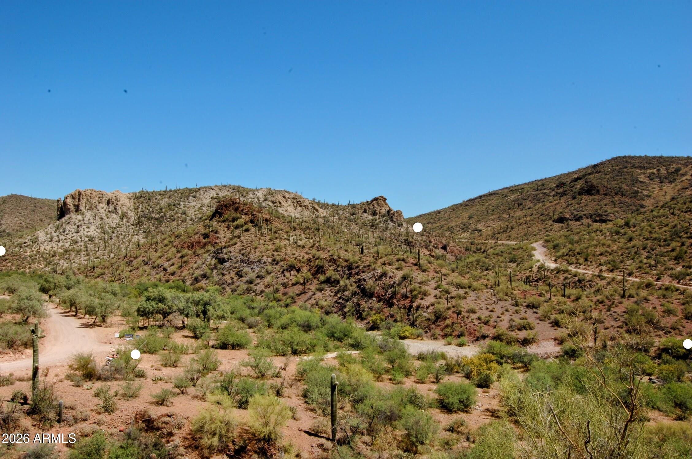 Exceptional 42.25-acre desert parcel in Pleasant Country Ranches--truly one of the finest in the community. A seasonal creek runs along the southern boundary with surface water present much of the year, creating a rare and beautiful setting. Majestic rock outcroppings rise hundreds of feet above the creek, with saguaro-studded hillsides and multiple flat  building sites among the shade trees. EZ access to roads and nearby power.
This parcel was once part of the historic S V X Ranch, where Francis Bard and Jack Humphrey developed the rare Barzona cattle breed--built to thrive in Arizona's desert. The ranch headquarters overlooks the creek, near the old creekside well & below the old dam. 
A spectacular opportunity for a private retreat, or legacy property in a truly exceptional setting.