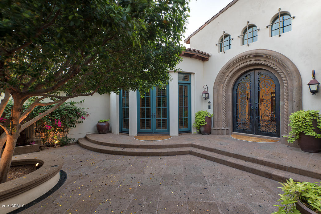 Timeless and meticulously built Mediterranean on a 1.36 acre privately gated lot.  This unique setting offers extensive privacy and mountain views. A true entertaining back yard with expansive Ramada w/swim up bar and quaint covered patios. Guests will be greeted by the exquisite front courtyard with fireplace. Beautiful Master bedroom with sitting area, 3 additional bedrooms, wood-clad Office, Gameroom and Fitness room in the main home plus a 1-bedroom guest house. Soaring ceilings with masterful wood work throughout.