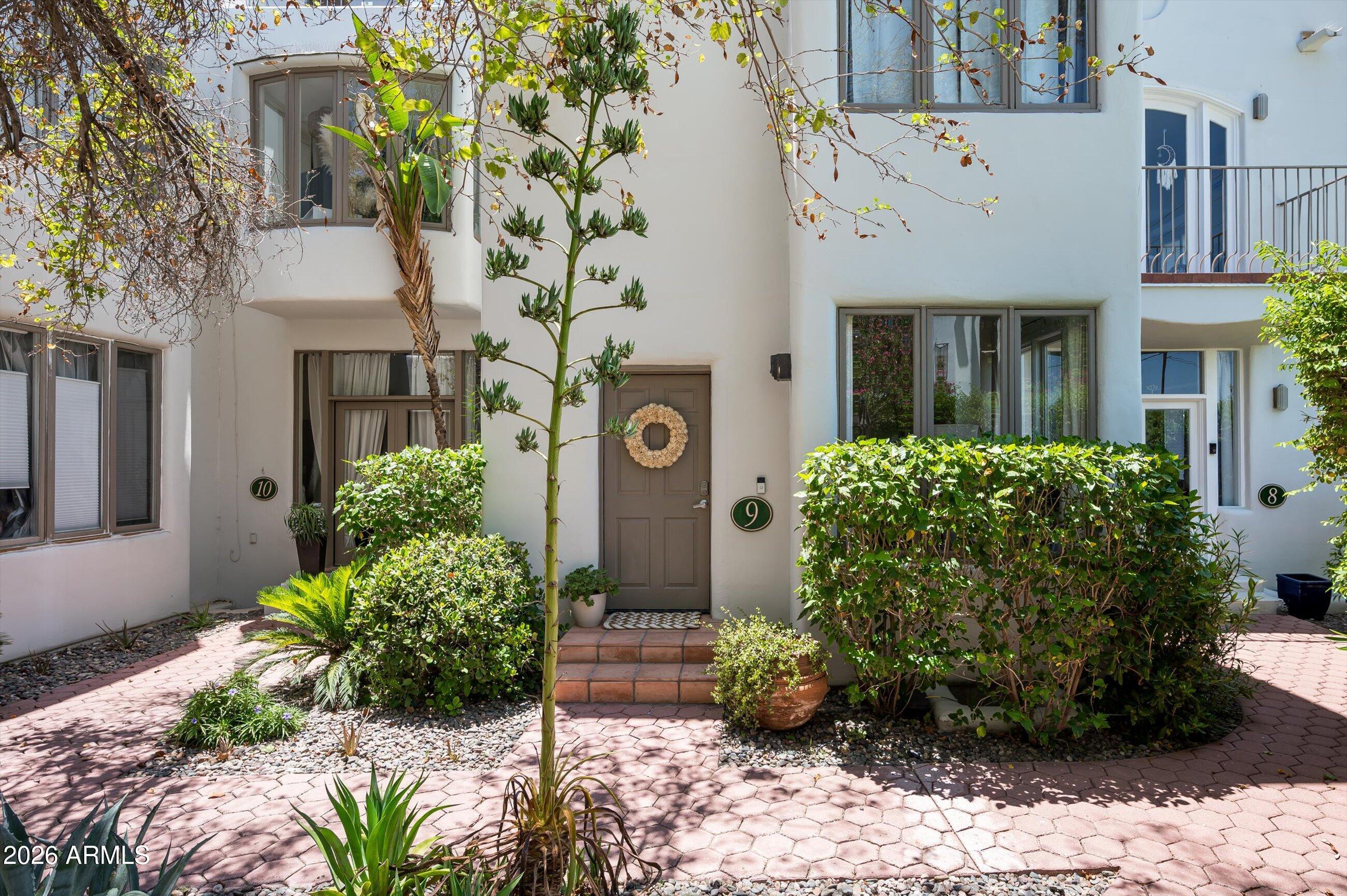 A little slice of the Mediterranean right in the heart of Arcadia...welcome to Arcadia Gardens! This 12-unit community offers a peaceful and tranquil lifestyle, with lush landscaping abound and a sparkling pool, it's just minutes from a litany of outstanding dining, shopping and entertainment experiences. This immaculate home is move-in ready and features an upgraded kitchen that boasts dark cherry wood cabinetry, SS appliance package, double ovens, a coffee bar w/ wine fridge, and quartz countertops. Large windows provide an abundance of natural light throughout. Enjoy outdoor living on the large patio, with direct access to the parking lot for added convenience. The upstairs features 2 en-suite bedrooms, with the back bedroom providing direct access, via spiral staircase, to the patio. Up one more flight of stairs and you will find your very own private rooftop deck appointed with Trex decking. This is an absolute must-see, as these units are rarely available.