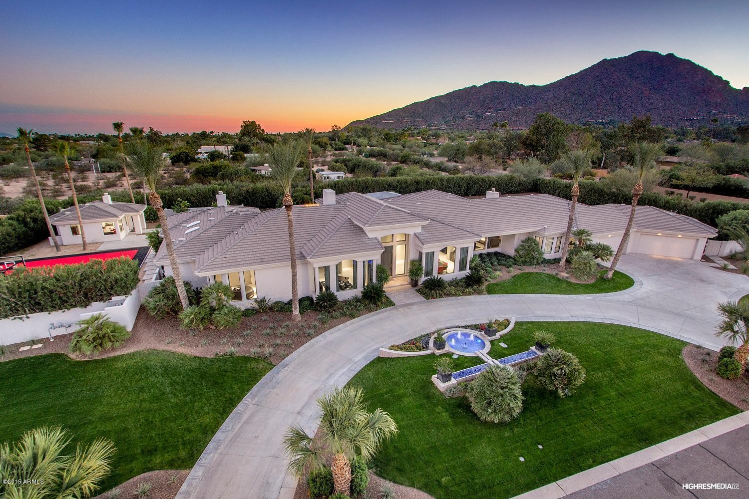 Everything a buyer could dream of located in the heart of Paradise Valley. This 4 bedroom/5.5 bathroom plus guest house(1 bed/1bath) was professionally designed w/ entertainment in mind. Grand foyer, elegant living room, chef's kitchen(Wolf dual oven w/ 6 burners & griddle, 2 warming drawers), great room w/2 way fireplace, movie theatre, game room(wet bar, ice maker, dishwasher, fridge, wine fridge), master bedroom w/ sitting area, steam shower, 2 way fireplace, custom closets. Backyard is an entertainer's paradise w/ a heated 60' pool/spa, waterfall, gas fire pits/troughs, swim up bar, gazebo, Wolf BBQ grill, warming drawers, mini fridges, ice maker, sport court. Crestron home auto, automated window drapes/blinds security cameras, surround sound, Lutron lighting and 20 TV's! Move-in ready