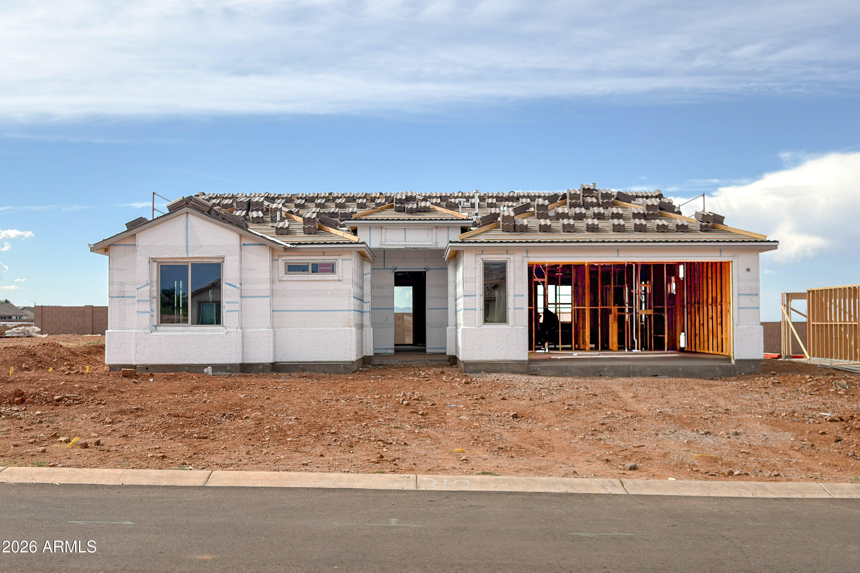 Located in the desirable Buffalo Soldier Ranch community, this 3-bedroom, 2-bathroom home w/ 2.5 car garage features 9' flat ceilings and a bright open layout. Expansive windows bring in natural light, with ceramic tile in main areas and carpet in bedrooms. Kitchen offers quartz countertops, stainless steel appliances, island, and eat-in dining. Ceiling fan pre-wires in living room and all bedrooms. Primary suite includes a walk-in tile shower, no tub, with executive-height quartz counters. Block wall rear yard provides added privacy, with a covered patio for outdoor living. HERS Rated & Environments for Living Guaranteed
