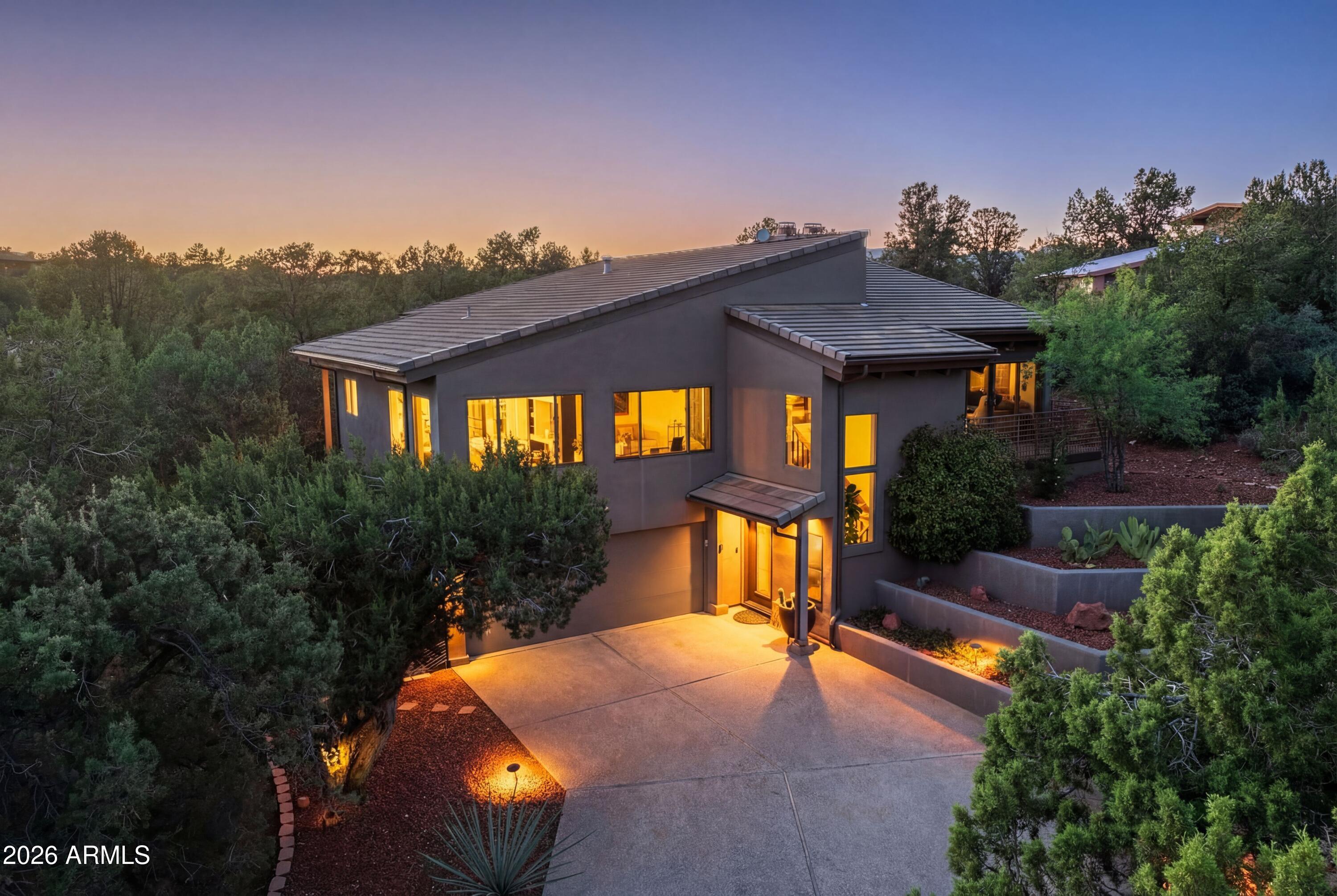 Modern Elevated Luxury in Prestigious Gated Foothills South.  Elegantly updated home with a spacious 3,189 SF | 3BR + office | dual kitchens | multigenerational living nestled on a private, nearly half-acre parcel in the coveted community of Foothills South, this West Sedona gem offers a blend of seclusion and splendor that is rare to find. Extensively remodeled since 2023, this home has been transformed into a modern sanctuary designed for flexible living, whether as a grand family estate or a sophisticated multigenerational retreat.The Main Level: Living Among the Treetops - The upper level welcomes you with a sophisticated open entry staircase, vaulted wood ceilings that make you feel as though you are living in an idyllic forrest where you can escape, recharge and get your Zen on. Brand New Kitchen (2023): Completely reimagined with custom cabinetry, sleek granite countertops, with dining area surrounded by large windows for full forrest effect. Kitchen also opens onto an upper deck perfect for your secret herb garden. High end finishes, gas cooktop.
Sun-Drenched Living: A spacious living room with private sitting deck, along with a signature fireplace flowing into dining and conversation areas where light pours in from generous windows, framing glimpses of Bell Rock, Cathedral Rock, Airport Mesa and The Rim through the lush green tree tops. 
Primary Sanctuary: The main upper level primary suite is a true escape, with a spa like en-suite, two walk-in closets, convenient laundry room and access to a private deck.
Convenience: A guest bedroom with a Murphy bed and a fully remodeled guest bath complete the upper level.
The upper level contains two spa like baths with the lower level having a walk-in shower.  The seller will offer a credit to any buyer wishing to convert the upper bath to a walk-in shower layout.

The Lower Level: 
A True Second Home - The ground level is a masterpiece of functional design, completely closed off for total privacy. It is ideal for an In-law suite, long-term guests, or a teenager's dream space.
New Kitchenette open to an expansive living area with a cozy fireplace.
Flexible Spaces: One additional bedroom and bath, a private office, and a media/family room that serves as a secondary Great Room. 
Indoor-Outdoor Flow: Easy access to the lower-level outdoor spaces and the garage.
Outdoor Splendor & Privacy:
The property sits on a lush 0.45-acre lot surrounded by mature trees and professional landscaping. Multiple decks and a private patio provide the ultimate setting for entertaining or quiet reflection under the Sedona stars, truly a magical enchanted woodland vibe.
With 3,189 square feet of meticulously updated living space, this home offers the "modern family" lifestyle in one of Sedona's most secure and prestigious neighborhoods. Experience the magic of Foothills South and make your Sedona dream a reality, today!
