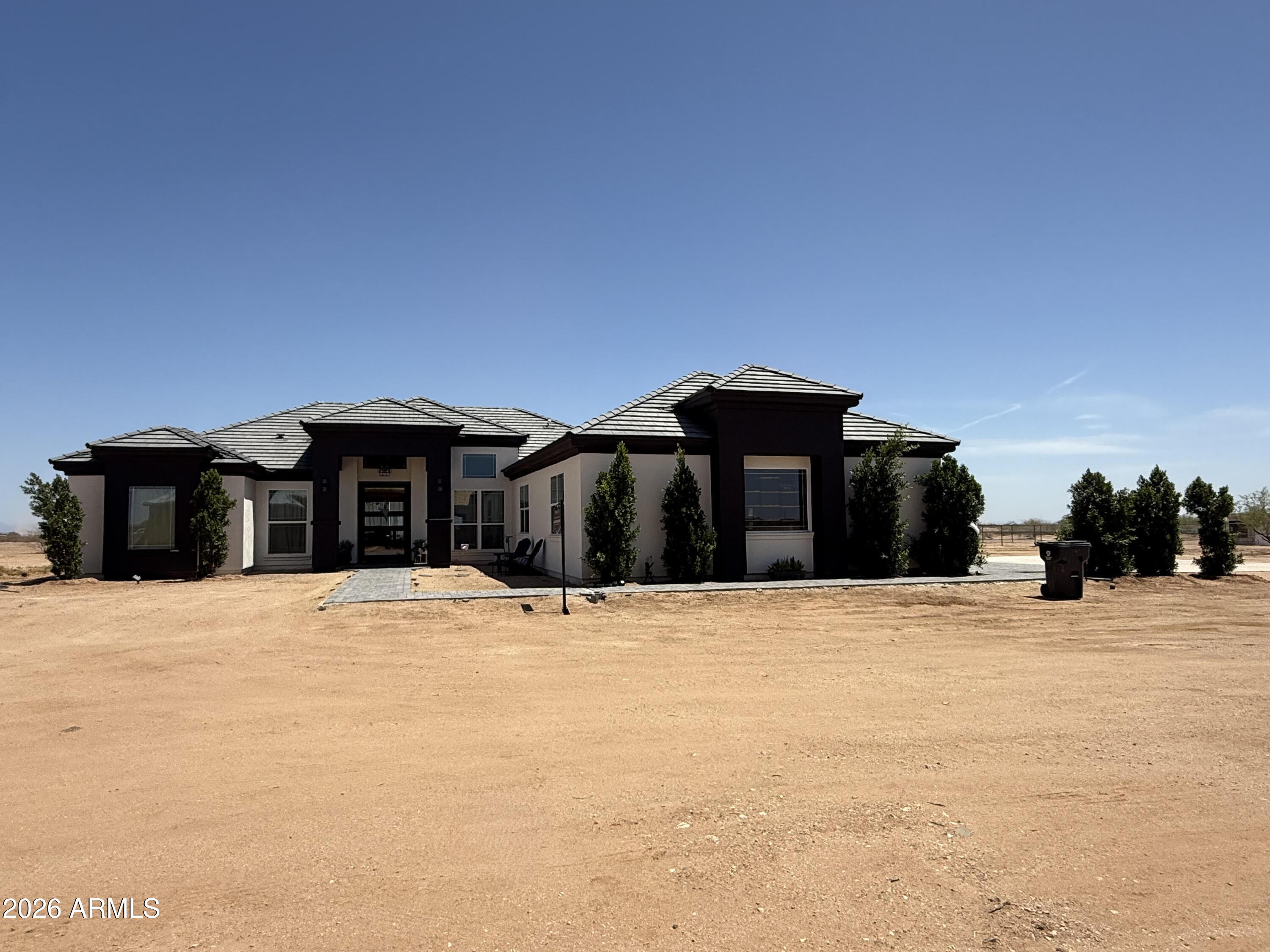 Beautiful custom home situated on a full acre lot [no HOA] featured in Wittmann, AZ. This home incorporates a subtle balance of contemporary finishes with a modern design while featuring 3bedrooms, +Den/4th bedroom, 3 full bath(s), 2,450 sq ft open concept floor plan, upon entry from the gorgeous 9 by 6 ft iron/glass pivot front entry door your greeted w/ 14 ft soaring ceilings, a gourmet kitchen equipped w/ quartz countertops, large [eat-in] island, shaker panel cabinetry, ss appliances, 36'' cooktop, and pantry. Also, this home features tile wood-plank flooring, modern plumbing/lighting fixtures [fans], dual pane [low-e] windows, two brand new 14 seer Trane HVAC units, dedicated dining space.. More... Freshly painted exterior. Interior will be repainted before closing. Spray foam walls and attic for that added R value to save on summer time utilities, 5/8 drywall throughout NOT 1/2, better noise control along with R value. 5. 5" floor trim, New ceiling fans throughout. Elegant lighting fixtures to give that modern farmhouse feel. All appliances are included except the washer and dryer. Newly installed brick veneer throughout the kitchen, from the countertop to the 10ft ceiling. Newly installed Electric fireplace. Brand-new, updated smoke detectors. Fully tiled showers. The 3rd shower has access to the back patio. All LED lighting is designed to help save electricity. Two 240V outlets in the garage for a welder and an EV plug, 44x22 concrete pad just poured for the back patio, for future pergola( have pictures of rebar and 24"x24" piers under the slab), 30x40 concrete slab poured additionally to the driveway next to the pavers, so you have plenty of parking. No expense was spared on this beautiful custom build. Not ALL new builds are created equal. Must see, to truly appreciate quality along with stunning accents.