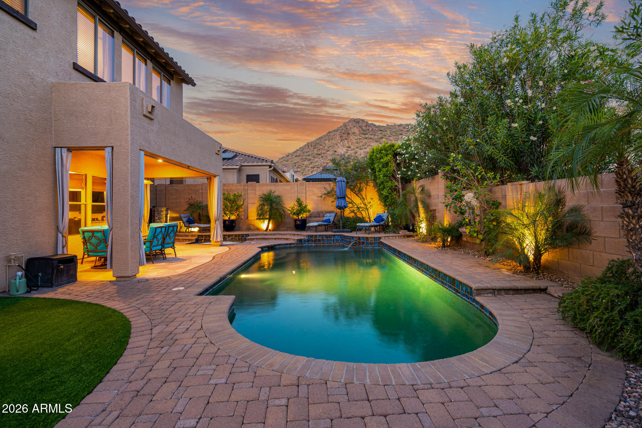 This house is a rare find in Phoenix, nestled in the quiet neighborhood of upper Tramonto, blending resort-style living with desert oasis. Recently painted outside! Imagine stepping into your dream home where every detail has been meticulously crafted to create an unparalleled living experience. This elevated property offers a stunning backyard paradise with mountain views, designed for both relaxation and entertainment. Enjoy the privacy strategically created through mature, yet low-maintenance landscaping, artificial grass area, and complemented by a covered paver patio with outdoor fans and flagstone extension. Beauty blends with functionality as you unwind in the  deep blue pebble-tec pool with multiple water spouts, decorative tile and separate hot tub, both equipped with a solar heater that can be effortlessly diverted from the pool to the spa, ensuring year-round enjoyment. Host gatherings with ease at the built-in gas barbecue and entertain friends at the spacious gas fireplace with extended seating and built-in cement entertainment pub table.
 
Inside, you'll be greeted by a warm, inviting atmosphere featuring a versatile cozy formal living room/flex space with courtyard views and an impressive staircase with high ceilings white plantation shutters, and decorative wrought iron twist and knot banister that sets the stage for a grand entrance into luxury.  Also, situated with a courtyard view and cactus garden, you'll find ultimate elegance with the formal dining room featuring high ceilings, custom curtains, and chandelier sure to impress family and friends.
 
The heart of the home, the enormous kitchen, dazzles with custom white cabinets with softclose, light granite countertops over large extended island, ideal for hosting parties, potlucks, or family night, a stylish stone backsplash, and extra lights. Equipped with modern stainless-steel appliances, gas oven, new stainless refrigerator, this culinary haven features a long breakfast bar and a charming eat-in breakfast nook with chandelier, extended cabinets for extra storage, and butler's pantry.
 
The kitchen seamlessly flows into the main family room with a custom built-in media center with matching granite, soft-close cabinets, pull-out drawers, and glass shelving.  New ceiling fans and extra lighting has been added for a warm bright ambiance for that elegant feel. 
 
Additionally a convenient bedroom and full bathroom are located on the main level, perfect for guests or family, ideal for multigenerational living. Large floor tile on the main floor makes for less time cleaning and more time enjoying desert living.
 
Venture upstairs to discover a spacious remodeled primary suite that serves as a personal retreat with brand new upgraded carpet and padding. The light and bright en suite spa like bathroom features double sinks, remodeled cherry cabinets, granite countertops, chandelier, and a luxurious elongated soaking tub and spa pillow, walk-in shower with large tile, storage areas, and a place to sit, while a spacious double entry walk-in closet ensures ample storage. You'll find an additional bedroom with an expansive closet, perfect for guests or as a large home office. 
 
The loft/bonus room/flex area complete with a pool table negotiable with the home, invites fun and relaxation. 
 
Along with the primary, you will also find bedrooms three, four and five upstairs.  They are oversized and can be multi-use including the room off the primary which is currently being used as a bespoke closet. 
 
With a three-car tandem garage with temperature control, and a covered courtyard area, you'll have plenty of space for vehicles and outdoor enjoyment, a paved side yard with RV gate for additional outdoor storage. This home features multiple storage areas including under the stairs, multiple closets, and garage storage. New water heater! Ask about the low solar lease payments at $188.09. Home exterior painted May 2026!
 
Experience the perfect blend of luxurious living and comfort in this remarkable Tramonto East residence surrounded by open desert and protected desert preserve.  This home is ideally located near the community park.  Benefit from the low Tramonto HOAs while indulging in outstanding amenities, including picturesque parks, sprawling playgrounds, walking paths, two pools, tennis, basketball, sand volleyball, picnic areas and more!
 
This home truly combines luxury, comfort, and convenience, making it the ideal sanctuary for you and your loved ones. Are you ready to make it yours?