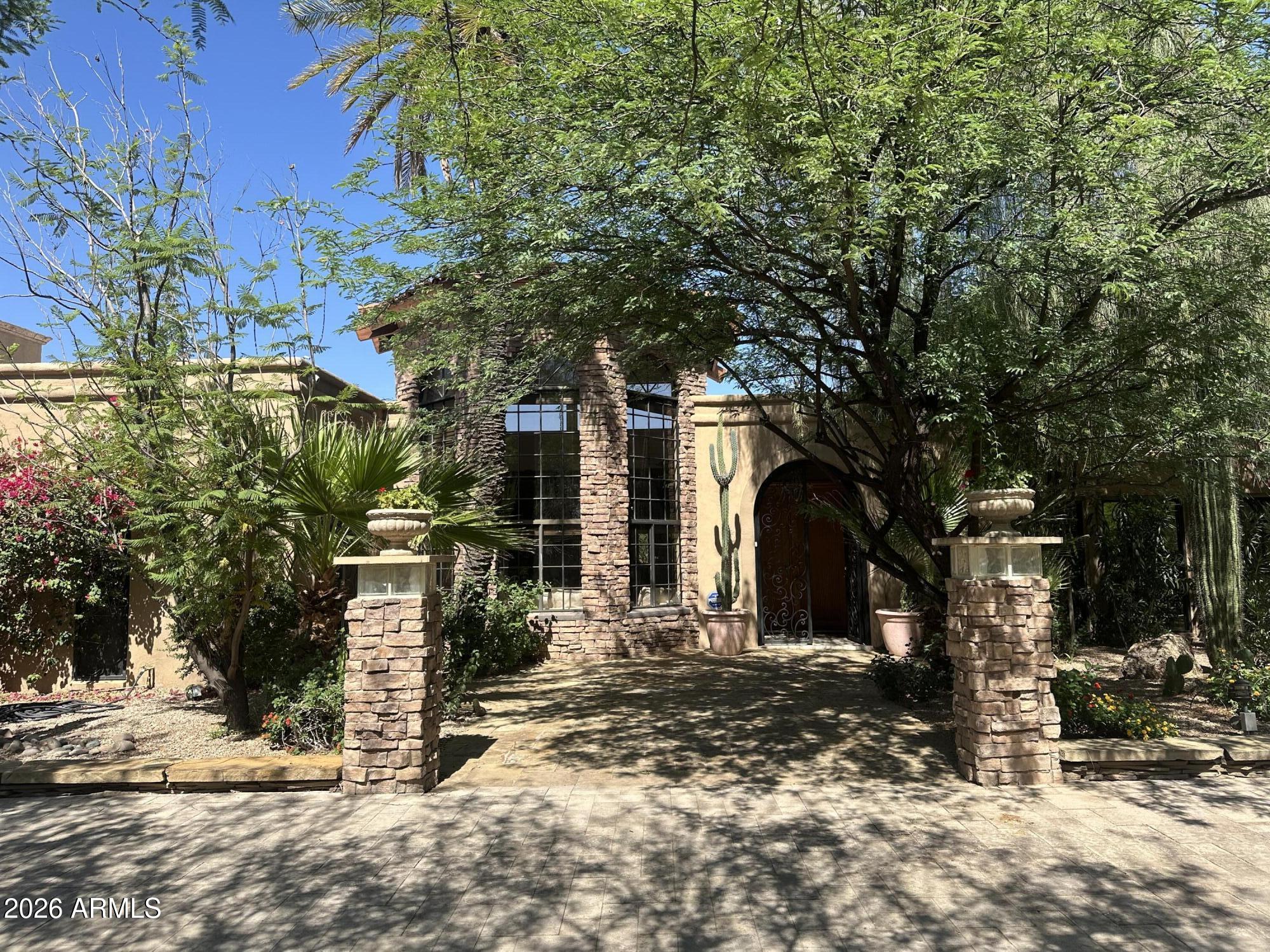A car collector and golfers dream home!  This gated property is set on 1 acre with incredible mature landscaping both front and back. Freshly restored to a high level of elegance and useability.  Over 2,400 sq.ft. of garages including large RV building with a triple car lift and 2 other  garages for up to 11 cars.  Highlight of the property is an incredible back yard with a 1700 sq. ft. putting green, large pool, Roman style cabana with fire pit, fire place and a waterfall surrounded by lush desert plants with over 10 large Saguaro cactus. Interior of the house has large open rooms highlighted with epoxy floors artistically done to look like a giant sheet of marble.  Lots of granite counter tops, travertine ,slate, custom office  and several chandeliers make this a very special property!