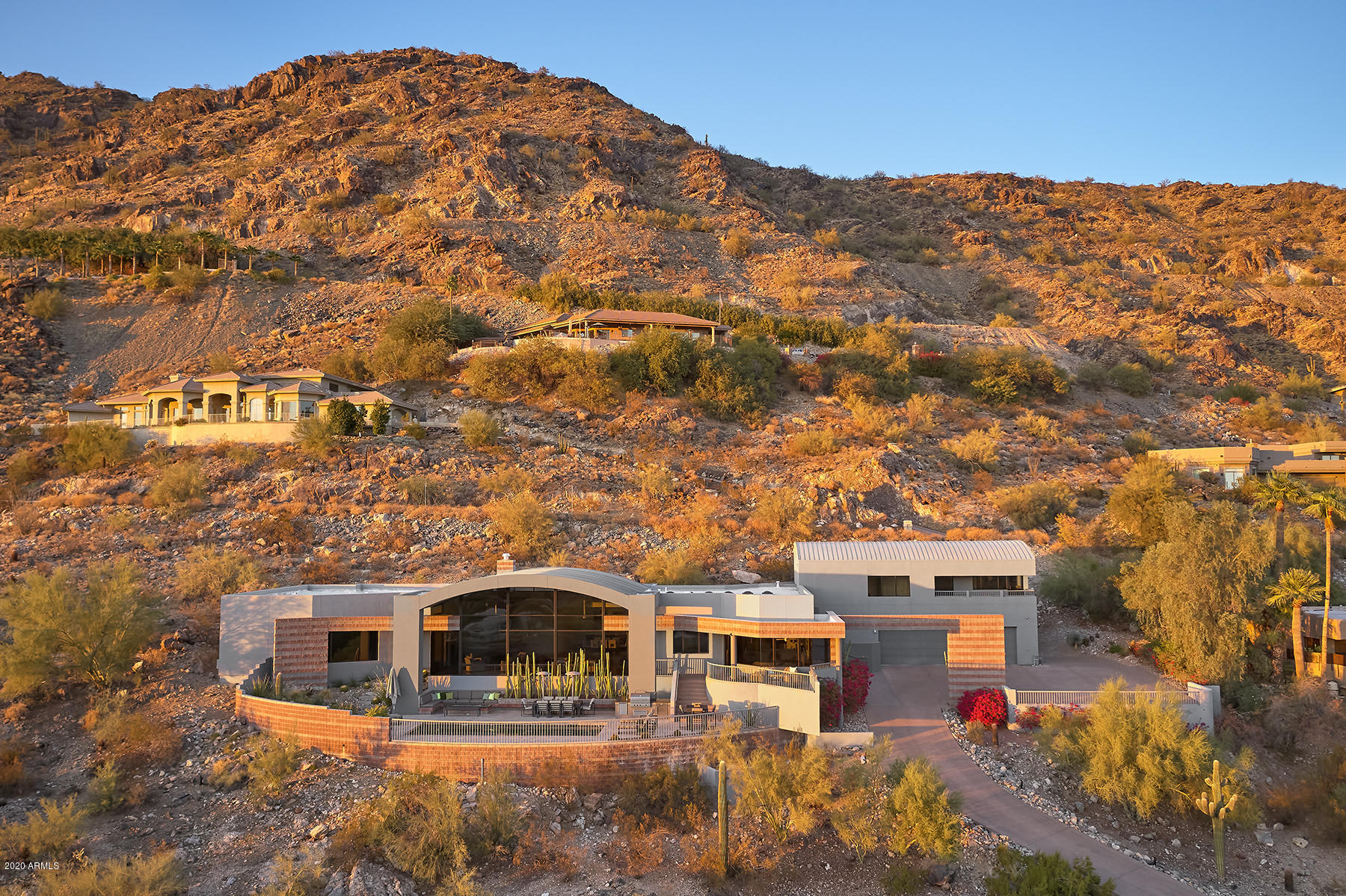 THIS IS WHAT YOU'VE BEEN WAITING FOR! A mouthwatering MODERN MASTERPIECE perched high atop Mummy Mountain taking full advantage of completely UNOBSTRUCTED panoramic CAMELBACK MTN, Downtown PHX Skyline, and Scottsdale city light views. Soaring ceilings let you drink in the landscape from inside this palatial PENTHOUSE estate. And much like an actual penthouse this home is incredibly low maintenance – with a finetuned backyard featuring a private pool, built-in seating, custom firepit, and built-in BBQ area.  The home lives all on 1 level with the Master, 2 bedrooms, 3.5 bath, an office, a highly upgraded chef's kitchen with Neff cabinetry, a sprawling 50' great room, and then, as a bonus, a large guest suite/game room upstairs with 2 walk-in closets & a sumptuous full size en suite bath. Expanded parking area allows for up to 9 cars. You're going to love everything about this property!