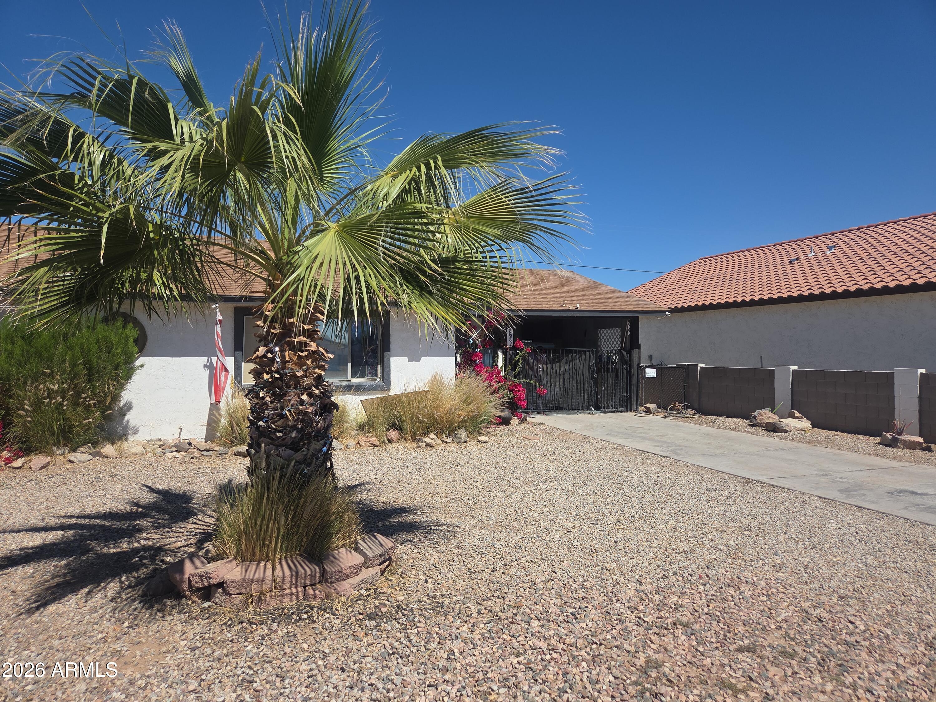 Affordable opportunity with strong potential! No HOA Single-level home with gated carport and key updates including newer roof, A/C, and water heater. Tile flooring throughout and a spacious living area. Bonus room with private entry, patio access, and mini-split A/C offers flexibility as a third bedroom, office, or additional living space. Large backyard ready for your vision. Located just one block from the golf course--great opportunity to add value.