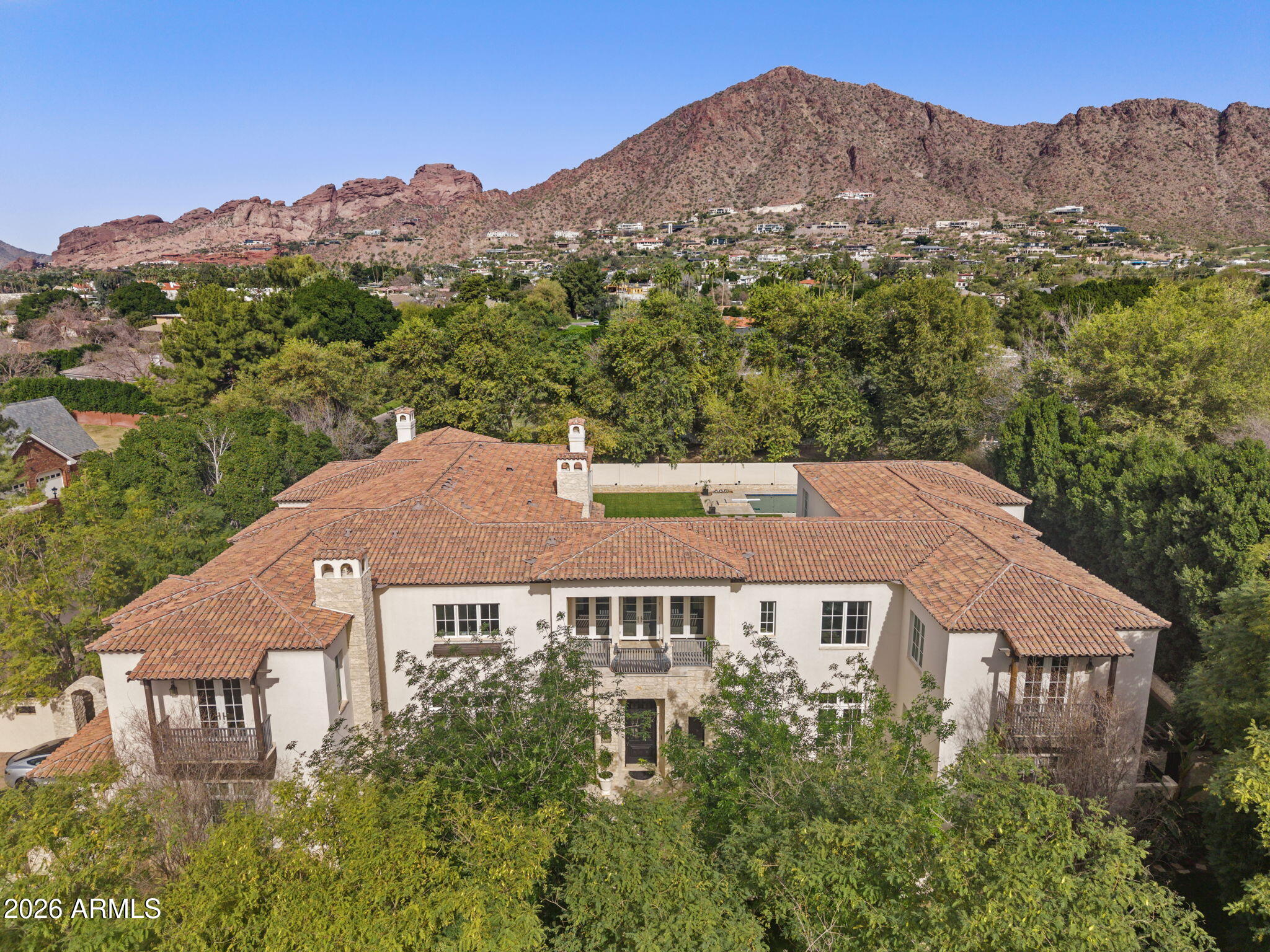 **$450k price refinement positions this home at $865/SqFt, presenting one of the most compelling opportunities and exceptional values in Arcadia Proper!**Welcome to one of the grandest estates on Exeter Boulevard, the most prestigious street in Arcadia Proper, and one of Arizona's most coveted neighborhoods. Spanning approx. 13,000 SqFt, this masterfully designed estate by renowned architect Mark Candelaria, blends timeless French + Mediterranean architectural elegance with today's modern-day luxuries, including your own private elevator. Situated on a sprawling 34,770 SqFt  corner lot on the North side of Exeter Boulevard, this home was built for cozy family gatherings or grand entertaining, while offering the ultimate in privacy, prestige, and prime Arcadia living. The showpiece chef's kitchen with dual islands is a masterpiece of design and performance, featuring custom cabinetry, dual Sub-Zero refrigerator + freezers, a commanding 60'' range with griddle, Wolf steam oven, a Miele built-in coffee system, dual warming drawers, and three dishwashers perfectly equipped for both everyday living and elevated entertaining. Featuring a striking custom 10' steel triple-basin sink & Waterstone fixtures, RH lighting, dual pot fillers, dramatic custom steel vent hood, and a fully appointed prep kitchen and expansive walk-in pantry provide seamless support behind the scenes. Stunning kitchen flows effortlessly into the great room and boasts automated sliding glass doors that open to the covered patio. 
The thoughtfully designed floor plan features 6 spacious bedrooms (each with its own en-suite bathroom, walk-in closet and French doors to private balcony), a beautiful separate office with French doors leading to the front courtyard + its own powder room and walk-in closet, 2 laundry rooms (one on main floor in mudroom and main laundry room upstairs), oversized formal dining room with French doors to front courtyard, sprawling living room area with grand fireplace and three sets of French doors that open beautifully to backyard courtyard.
The primary wing is a private tranquil retreat, featuring a stunning, resort-inspired bath, an extraordinary 700-square-foot boutique-style closet that blends luxury and organization, and a spacious bedroom with fireplace and separate sitting room both opening through timeless French doors to a serene balcony with its own fireplace, the perfect setting to unwind at day's end.
Impressive bonus/game room and entertainer's bar showcase beautiful accordion doors and windows that seamlessly open to the backyard and pool to enjoy true indoor-outdoor living. Complete with a convenient sink, beverage fridge, dishwasher, and ice machine, this space is perfectly crafted to host unforgettable gatherings with ease and style.
The spacious resort-style backyard (with no telephone or utility lines behind) features a sparkling diving pool and spa with water feature and newly upgraded Pentair equipment, beautiful brick gas fireplace + pizza oven, and built-in Viking BBQ, designed for unforgettable evenings under the stars. From the half sports court (with space for future pickleball!)  to the outdoor bath and separate pool shower, lush Ficus-lined privacy, built-in planter speakers, vibrant bar and lounge flowing from the game room, grand staircase to the primary balcony fireplace this extraordinary outdoor retreat is built for elevated entertaining, relaxation, and year-round enjoyment.
Designed for both function and convenience, the home includes dual 2-car garages (North and South), both newly finished with fresh epoxy flooring. The North garage also includes a rare climate-controlled storage room with direct backyard access.
Perfectly positioned near world-class shopping, dining, golf, and luxury amenities and in close proximity to top-ranked public and premier private schools just 5 minutes to The Global Ambassador and Scottsdale Fashion Square, 10 minutes to Old Town Scottsdale, the Biltmore, and Sky Harbor Airport, and 25 minutes to Scottsdale Airpark, with convenient access to I-10, Loop 202, and Routes 51 and 143 for seamless travel.