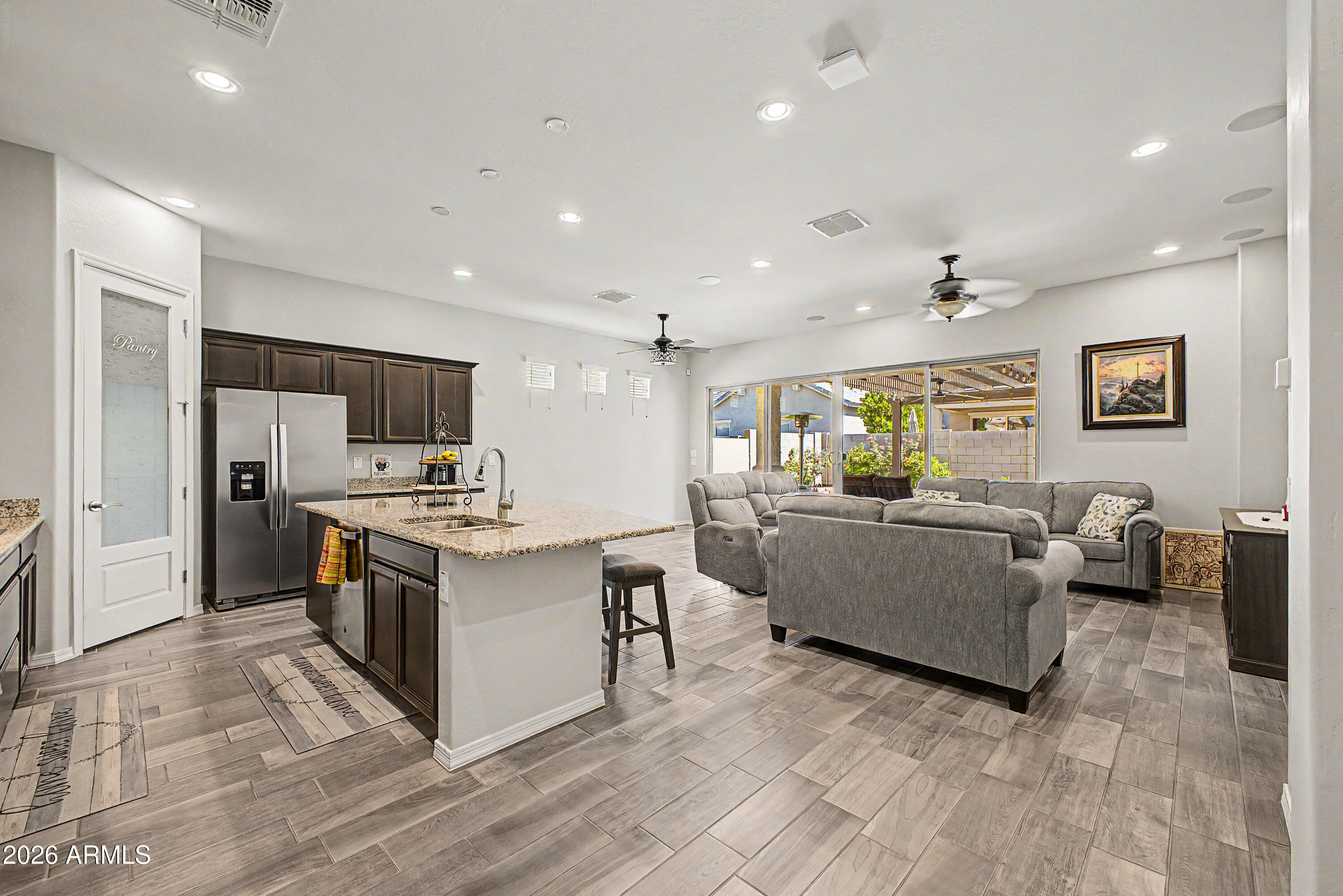 Welcome to this beautifully upgraded 3-bedroom + den home that perfectly blends comfort and style. From the moment you arrive, you'll notice the attractive curb appeal featuring paver driveway and walkways, manicured landscaping, turf accents, and charming covered entry architecture. Home shows like a model.

Inside, this thoughtfully designed   home showcases wood plank/tile flooring, soaring 10-foot doors, surround sound with 5 speakers and subwoofer, prewired security, and WiFi-enabled programmable features. The open-concept living space flows seamlessly into the gourmet kitchen complete with granite countertops, gas cooktop, designer hood, glass pantry door, and prewiring for additional kitchen lighting. Stove can covert to electric.  The laundry room features cabinets, a counter