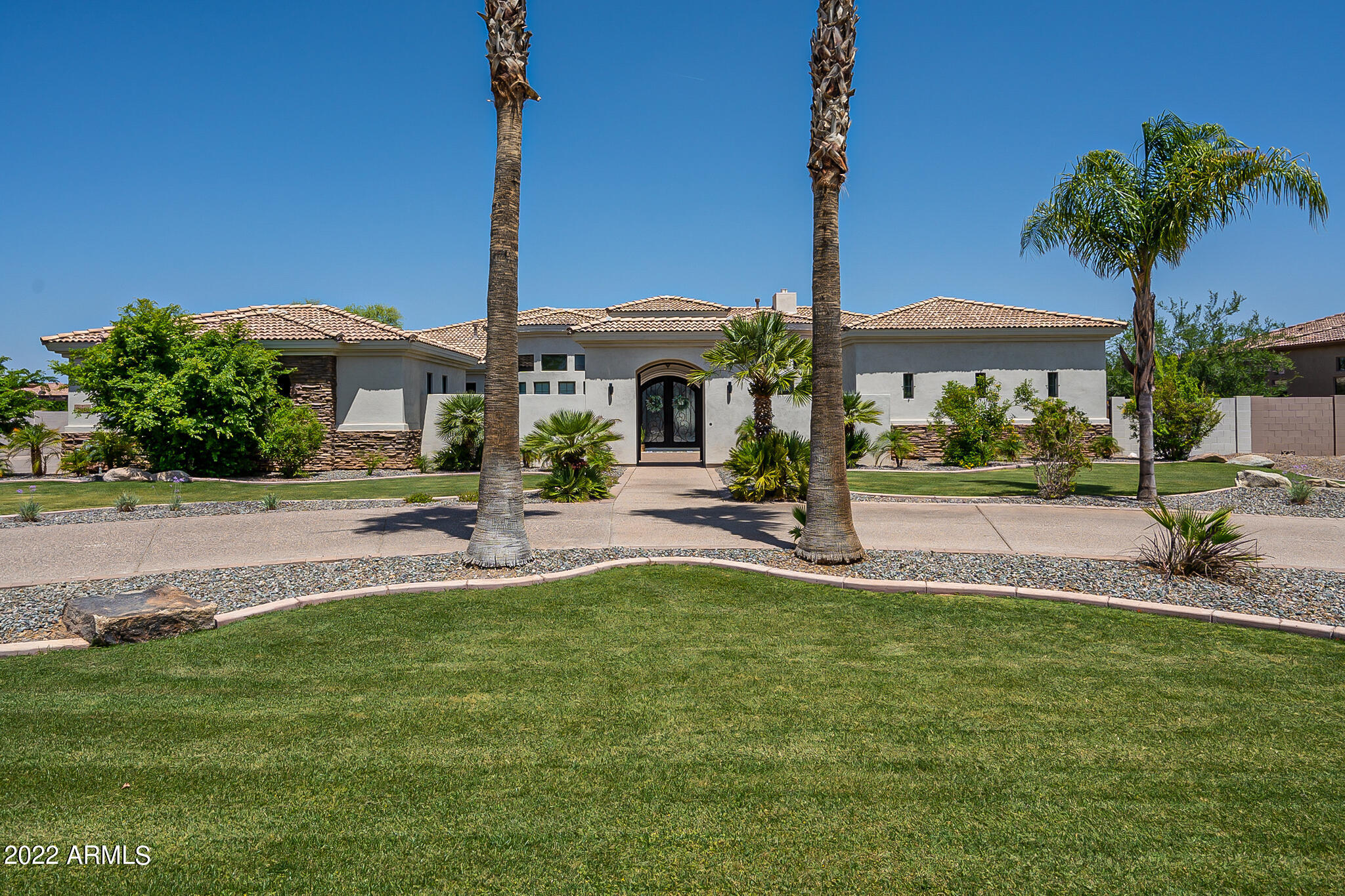 Completely remodeled (2021) 5300 sf custom home in gated Weston Ranch near the Gilbert Regional Park on more than 3/4 acre lot.
You're greeted with a huge private courtyard entry with iron gate. Inside, the light and bright open floor plan is complete with 4 bedrooms plus an office and theater-game room or den. Kitchen and bathrooms were stripped to the studs and re-done with high-end designer finishes. The brand new large kitchen features extensive cabinetry,  GE cafe series appliances including induction cooktop, quartz countertops,  beverage center, and butler's pantry. A large master suite wows with a luxurious free-standing tub, dual entry shower, and his/hers sinks and closets. The remaining bedrooms/bathrooms on the opposite side of the home, maximizing privacy and comfort An oversized 4-car garage completes the checklist of must-haves providing extra space for storage. 

The brand new,easy to maintain back yard (dirt to resort-style in 2020) impresses with an incredible entertainer's dream rec space.
A large 50' x 20' pebble-tec pool with built-in spa, baja shelf and 20' long jumping wall is beautifully surrounded with diamond patterned pavers and turf.  A huge sport court features TWO standard sized pickleball courts and half-court basketball.   
The extended covered patios allow for large groups in multiple  gathering spaces including one with a gas fireplace. 
The owners suite is complete with its own patio with free-standing hot tub and pergola.
